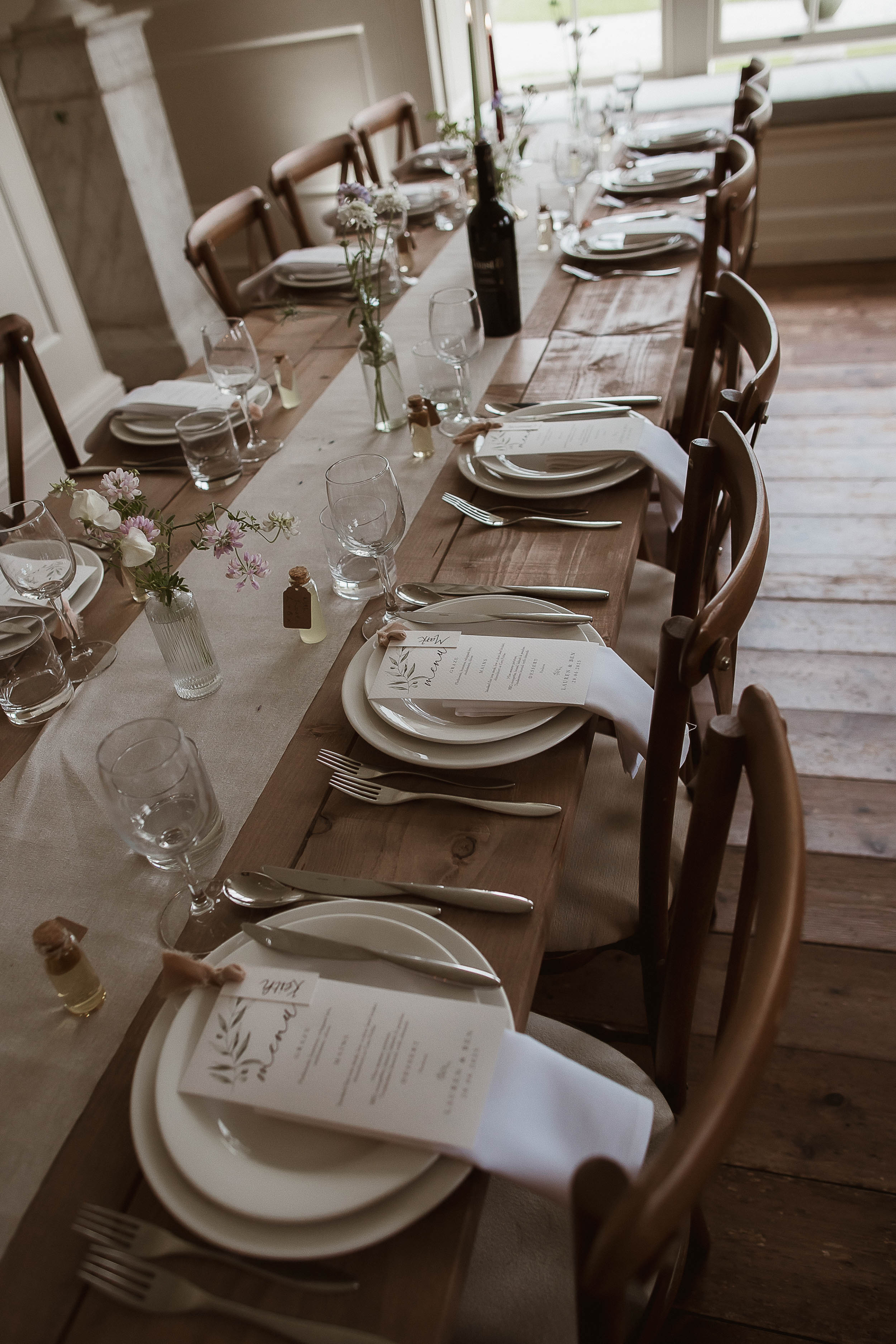 Boconnoc Estate Wedding Cornwall Jesus Peiro 126 - Lauren in Jesus Peiro for her Elegant Boconnoc Estate Wedding in Cornwall Elegant wedding table decor with taper candles in brown and green with a natural colour linen table runner, simple bud vases, natural colour tableware and printed menus.