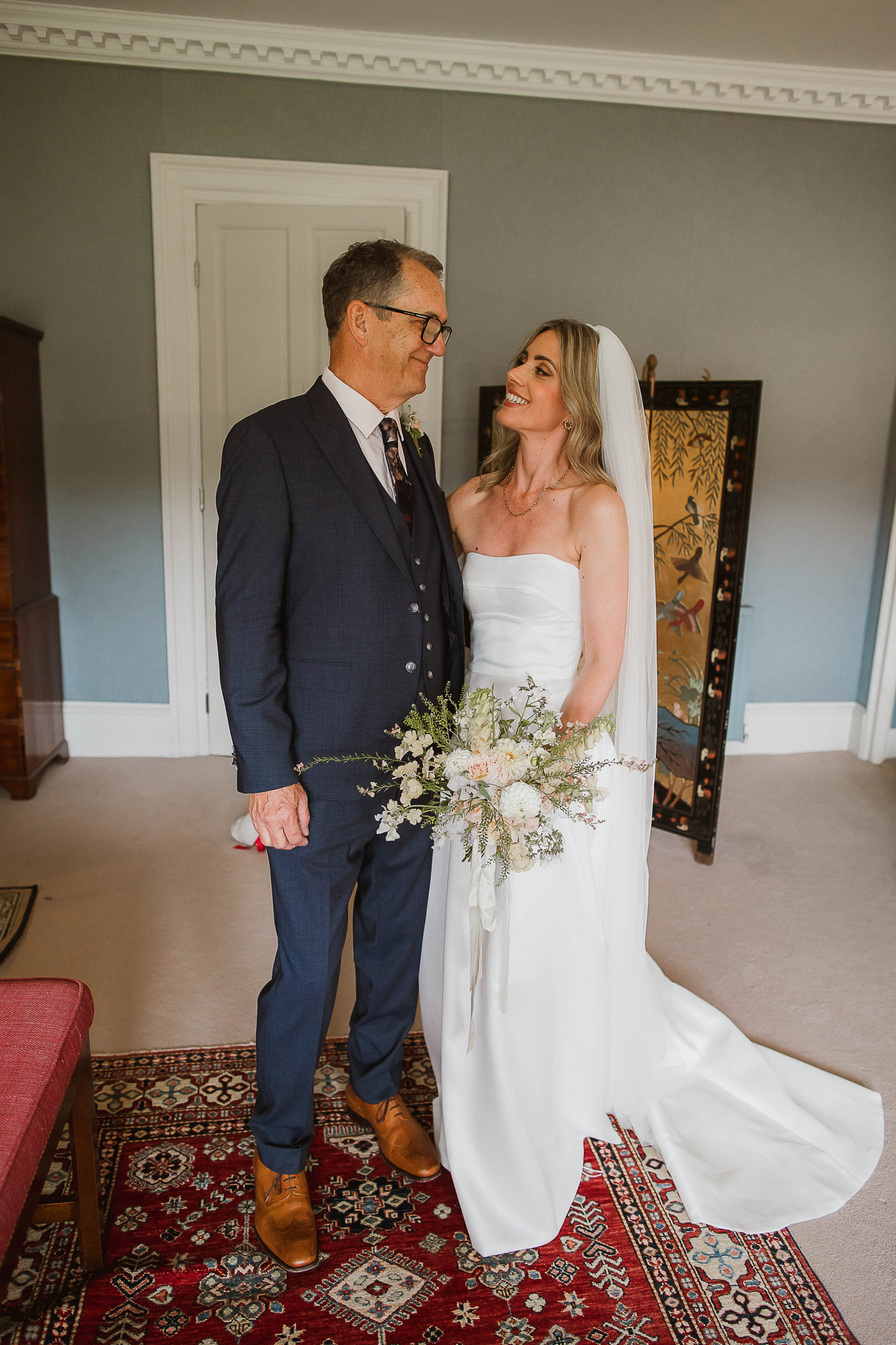 Boconnoc Estate Wedding Cornwall Jesus Peiro 52 - Lauren in Jesus Peiro for her Elegant Boconnoc Estate Wedding in Cornwall Bride in a Jesus Peiro wedding dress looking lovingly into her father's eyes. She also carries an elegant summer wedding bouquet in pale pastels.