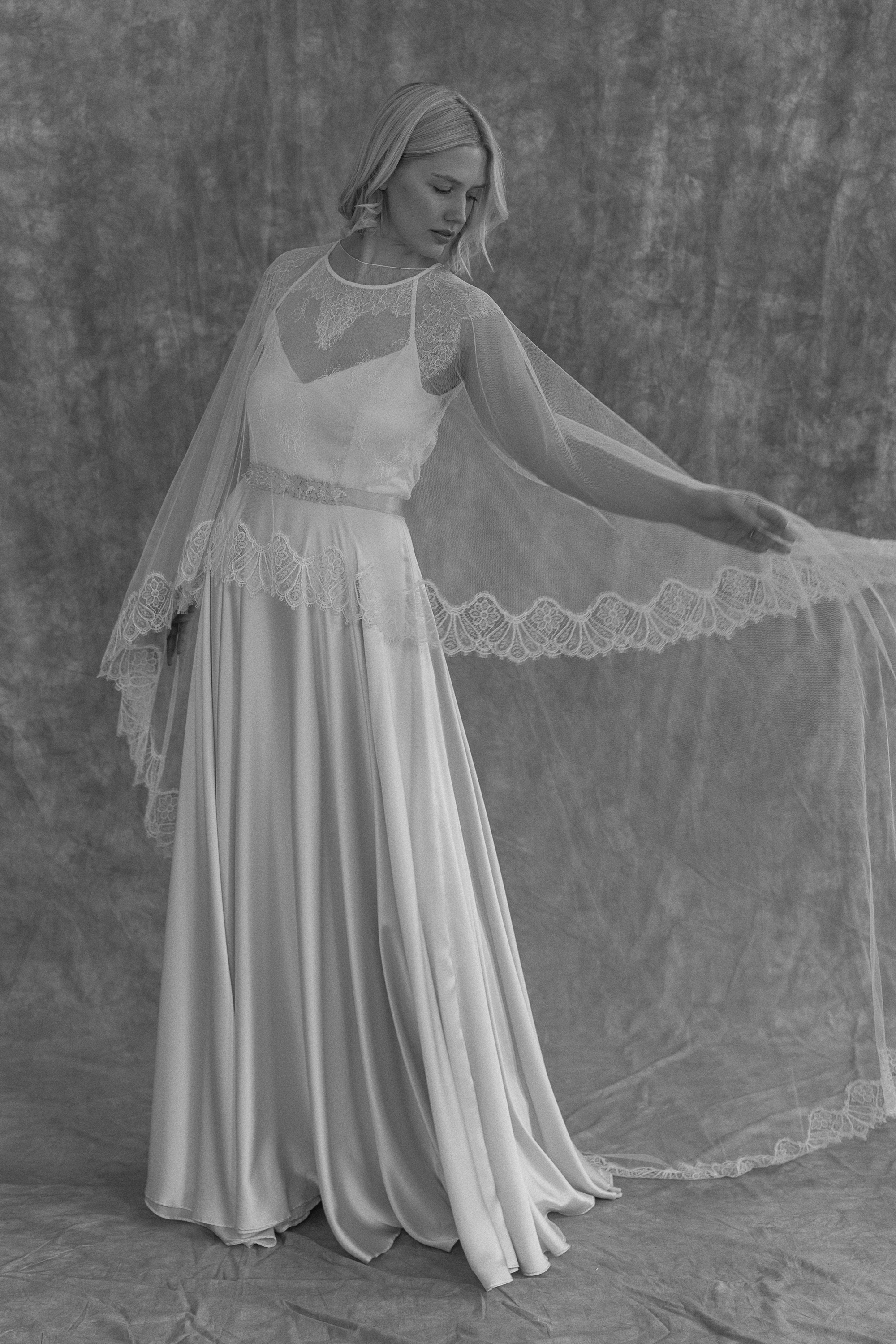 Clematis lace silk wedding gown KateBeaumont Icons 2 IndiaHobson HR 29 1 - Kate Beaumont: Lovingly Handmade Silk Wedding Dresses Black and white photograph of model bride wearing a silk wedding dress by Kate Beaumont and veil cape.