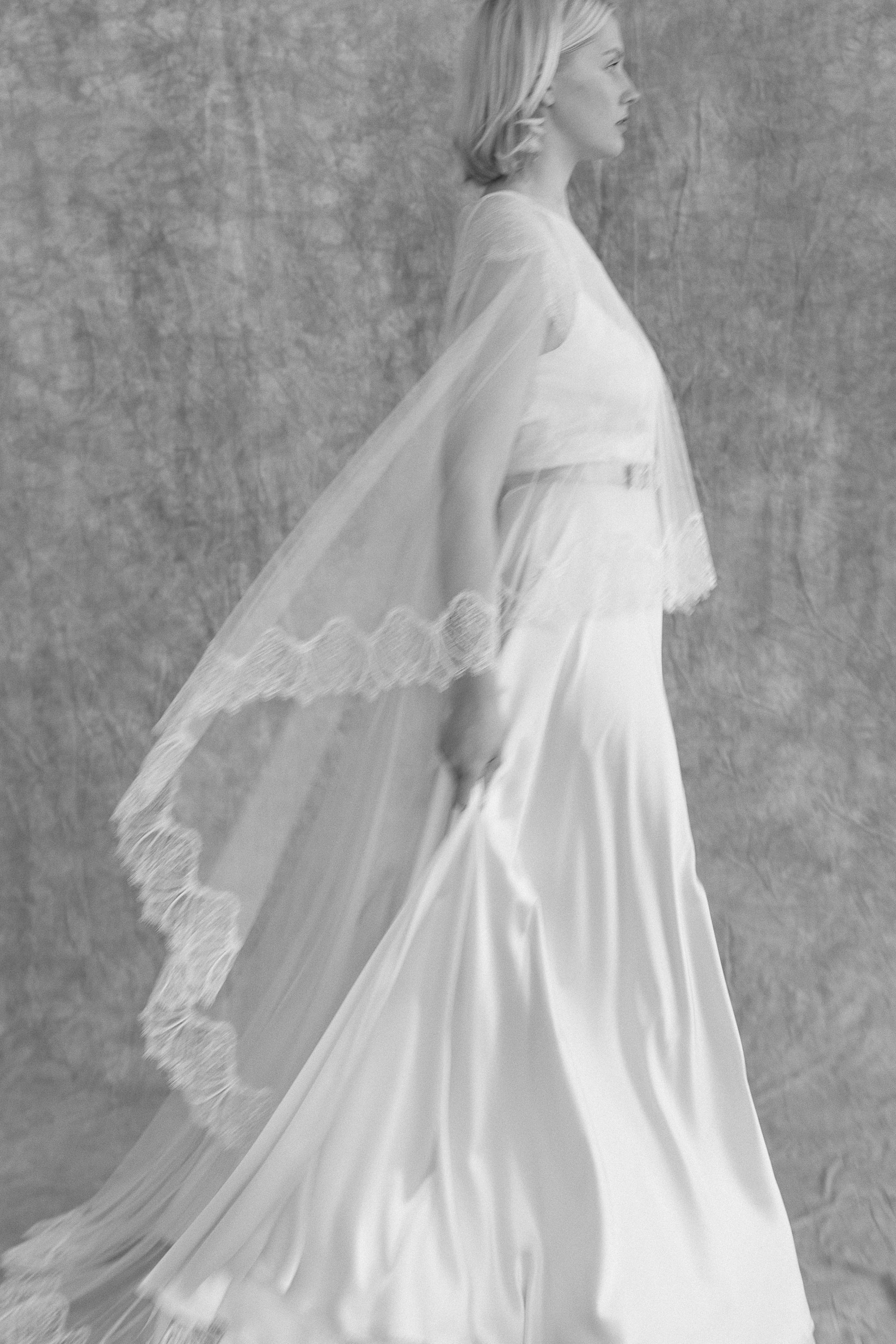 Clematis lace silk wedding gown KateBeaumont Icons 2 IndiaHobson HR 34 - Kate Beaumont: Lovingly Handmade Silk Wedding Dresses Movement shot of bride wearing an elegant silk wedding dress by Kate Beaumont and lace edged veil.
