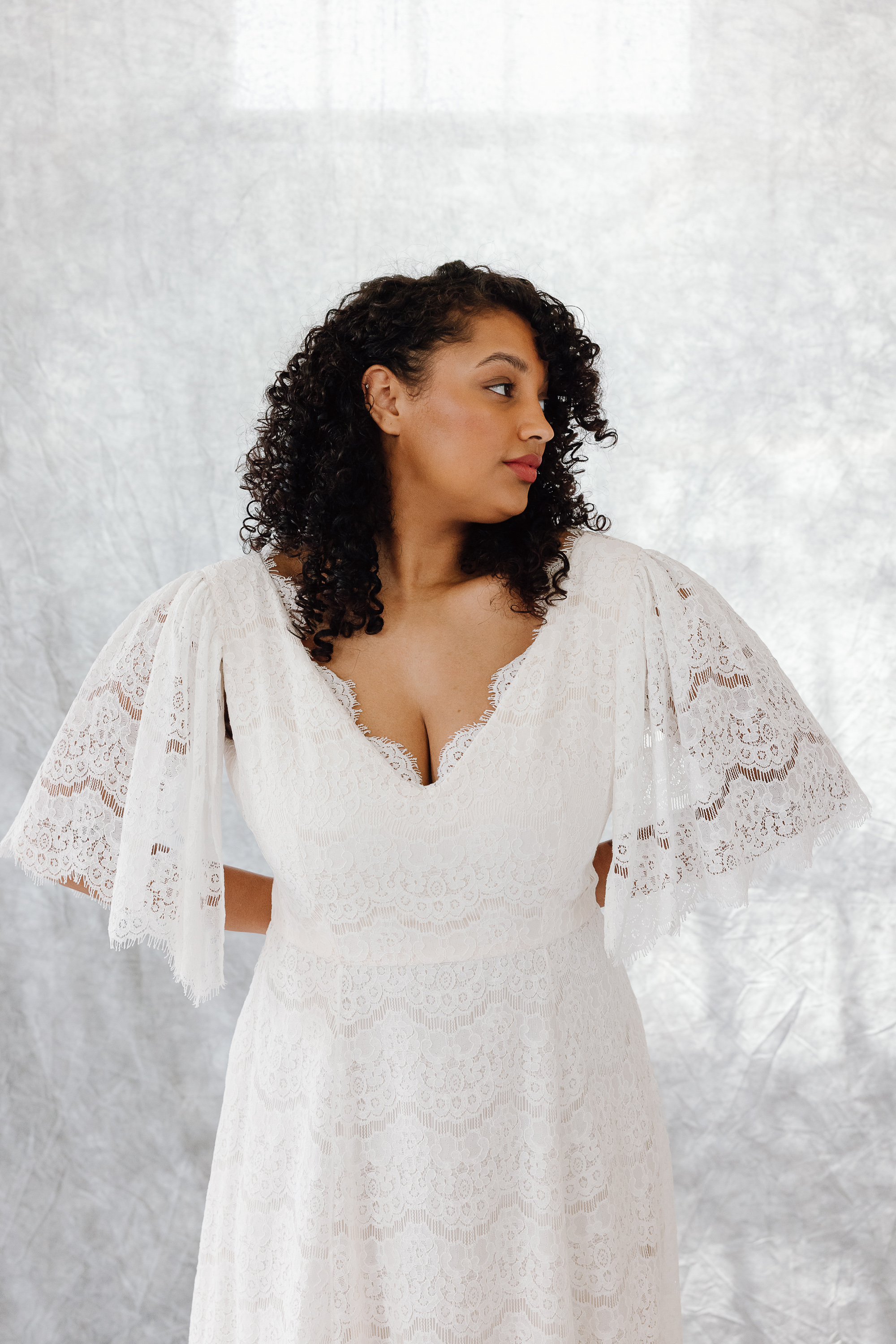Dahlia silk lace wedding gown KateBeaumont Icons 1 IndiaHobson HR 66 1 - Kate Beaumont: Lovingly Handmade Silk Wedding Dresses Black curvy model bride with loose curly hair, wering a lace wedding dress by Kate Beaumont.