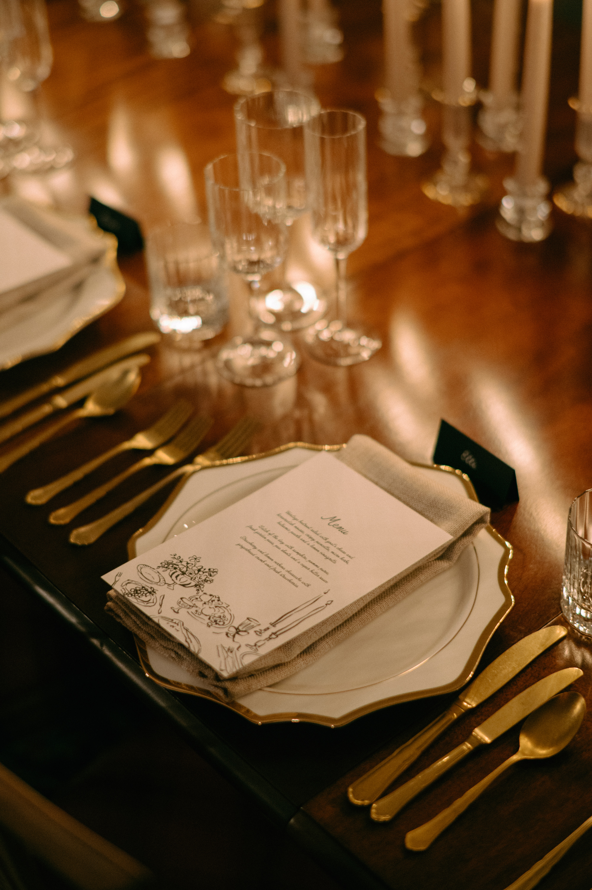 Earnshill House Wedding Editorial Fern Godfrey Weddings 62 - Modern Bridal Elegance at Earnshill House, A Romantic Somerset Wedding Venue Simple elegant modern wedding stationery sat atop a cotton napkin on a white china plate with gold rimmed edges. Gold cutlery and ribbed glasses. Earnshill House, a romantic Somerset county house wedding venue.