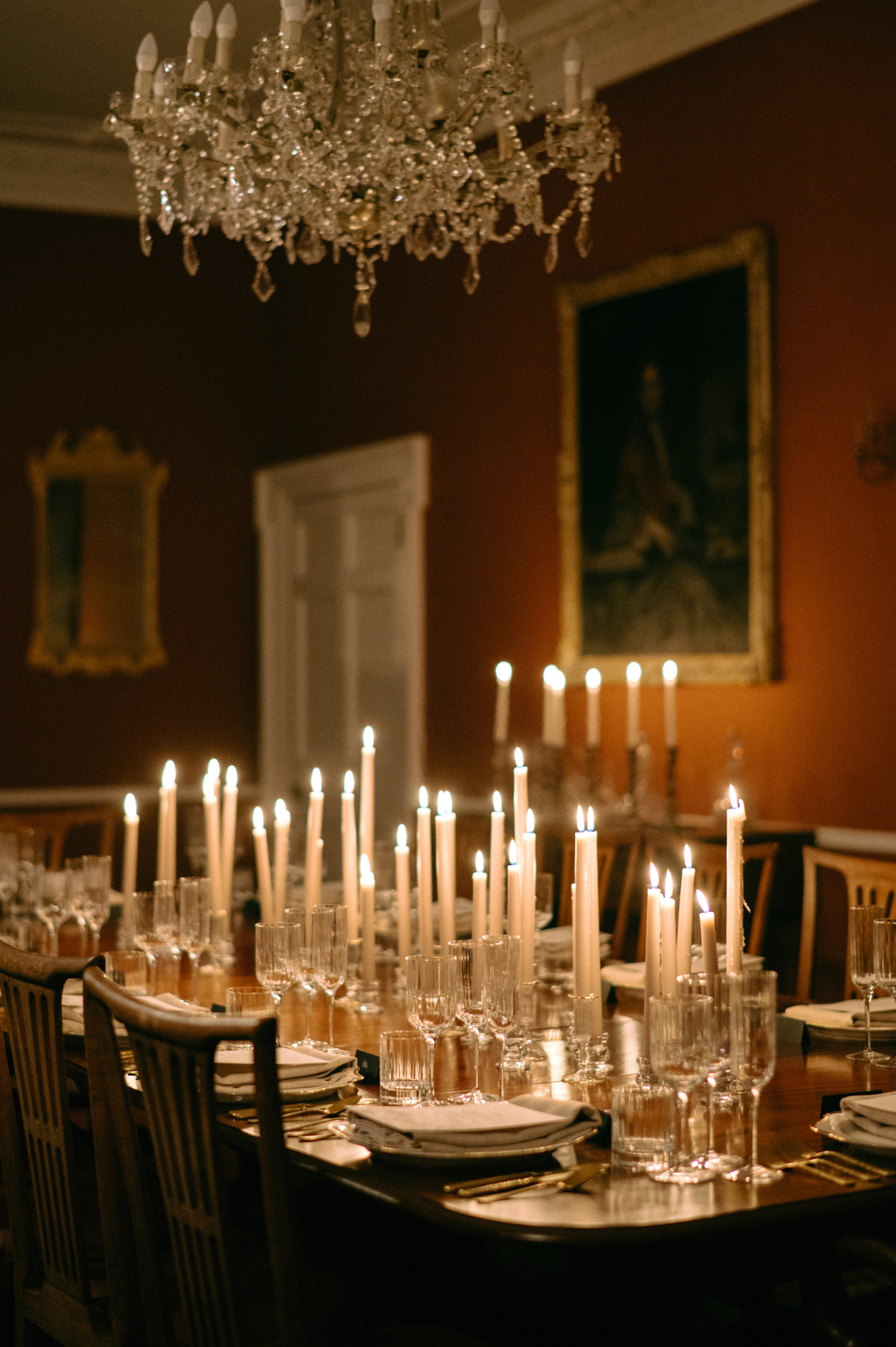 Earnshill House Wedding Editorial Fern Godfrey Weddings 68 - Modern Bridal Elegance at Earnshill House, A Romantic Somerset Wedding Venue Romantic candlelit wedding reception scene at Groom in black tie and bride in a JULITA dres with 3D silk roses wandering the gardens at Earnshill House, a romantic Somerset county house wedding venue. Tall white taper candles, ribbed glasses, gold cutlery and simple stationery keeps the scene minimalist but luxuriously elevated.