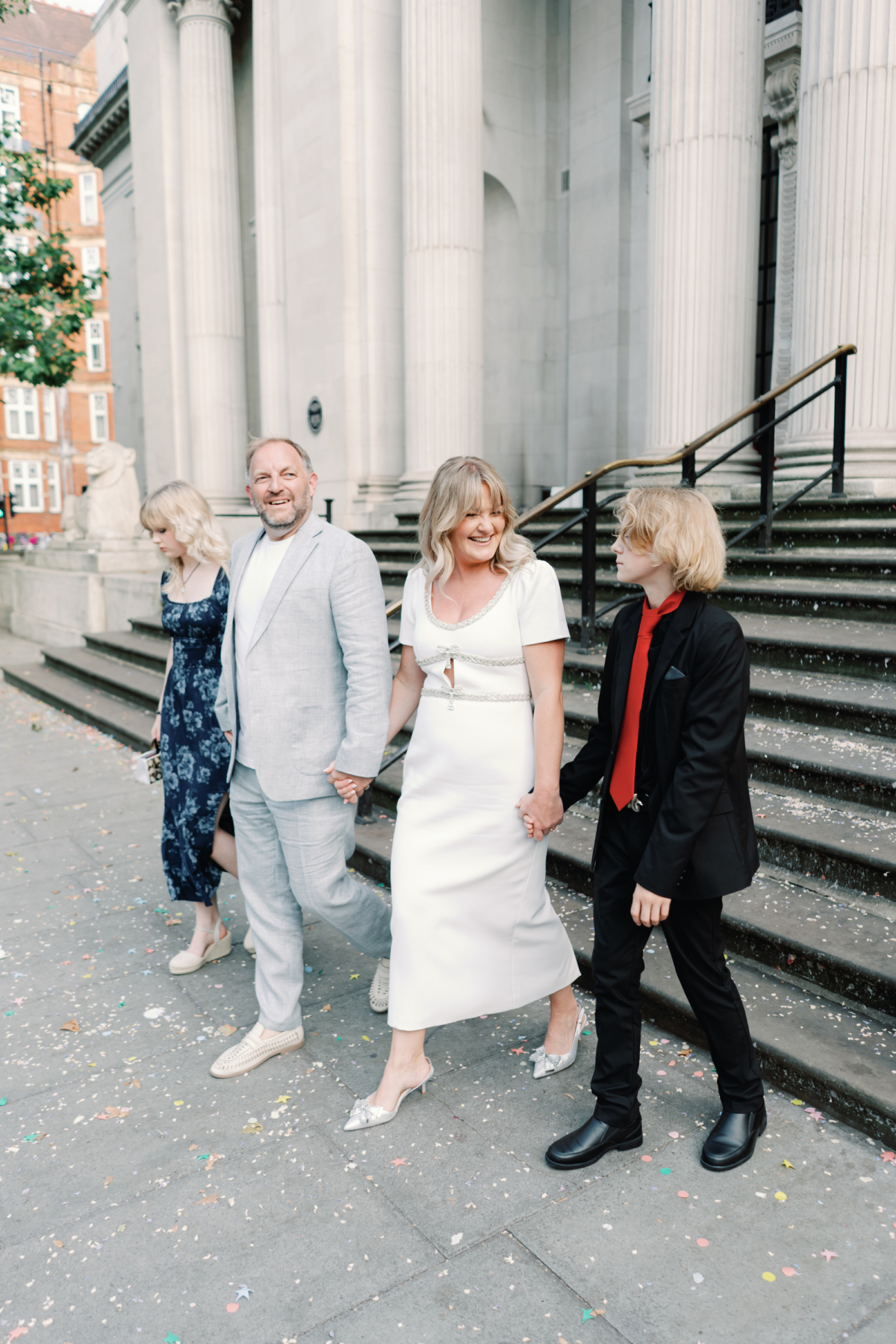 Wedding photographer Emmylou Kelly on her registry office wedding day. She wears a Self Portrait dress with capped sleeves. The groom wears a relaxed pale blue suit.