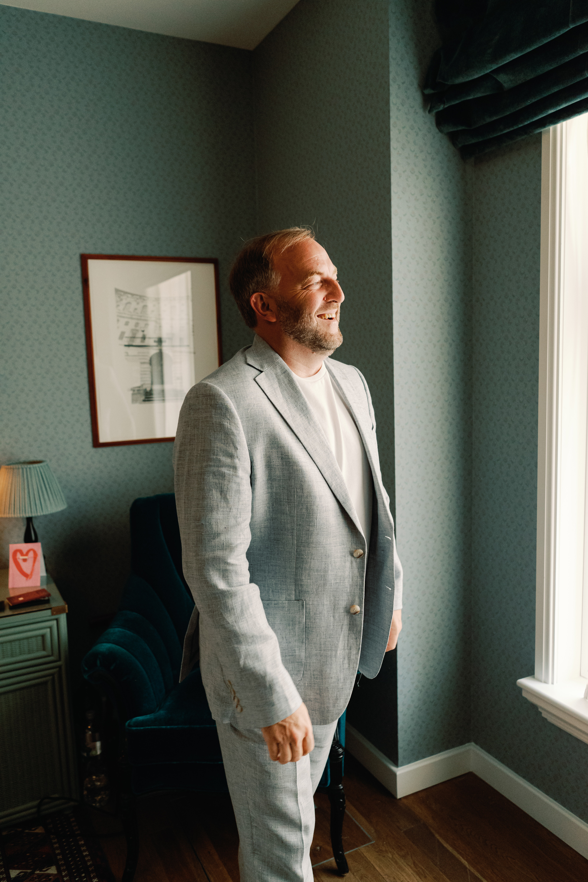 Groom in a pale blue suit and t-shirt by Moss Bros.