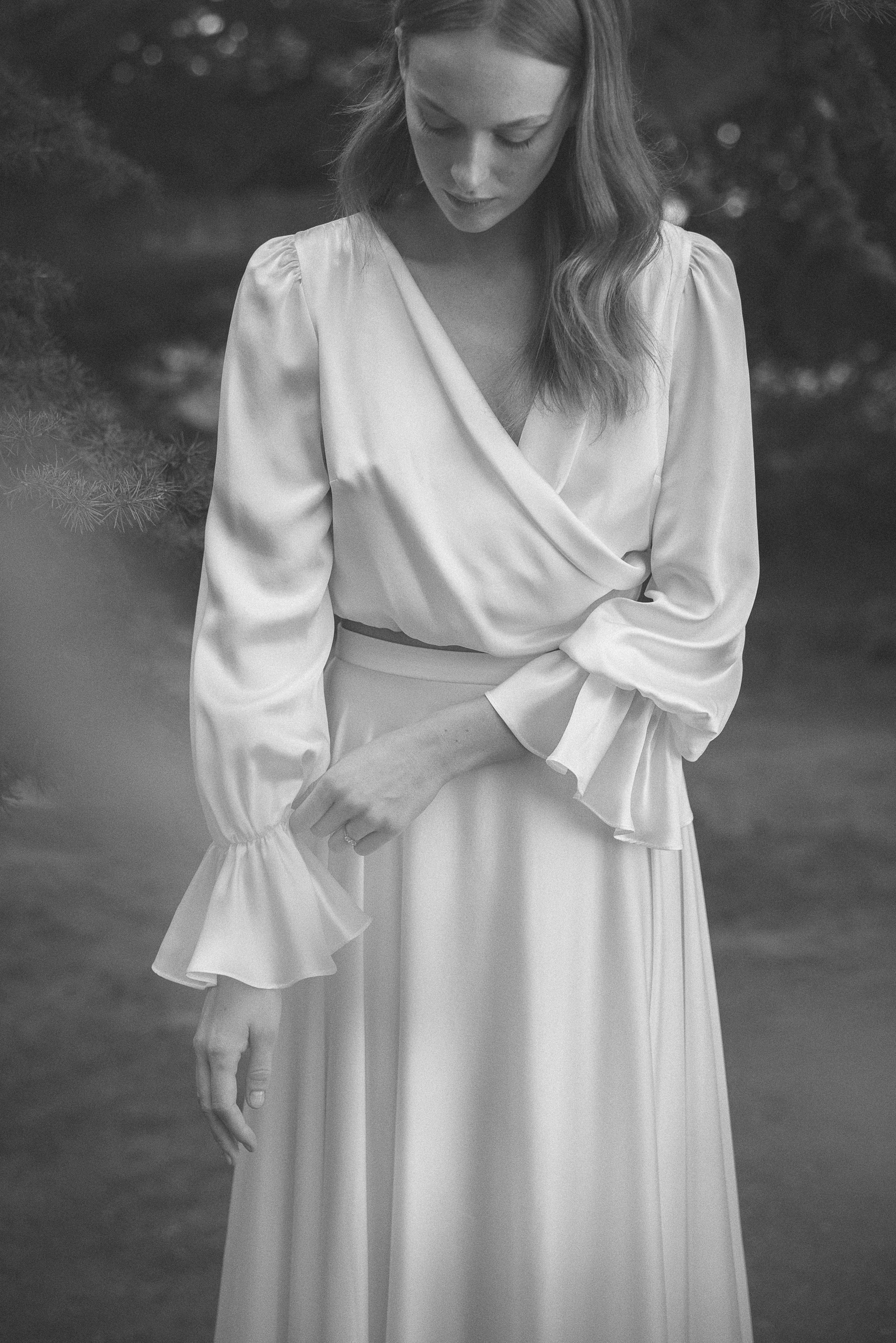Black and white photograph of silk bridal separates by Kate Beaumont with 3/4 length ruffled sleeve top.