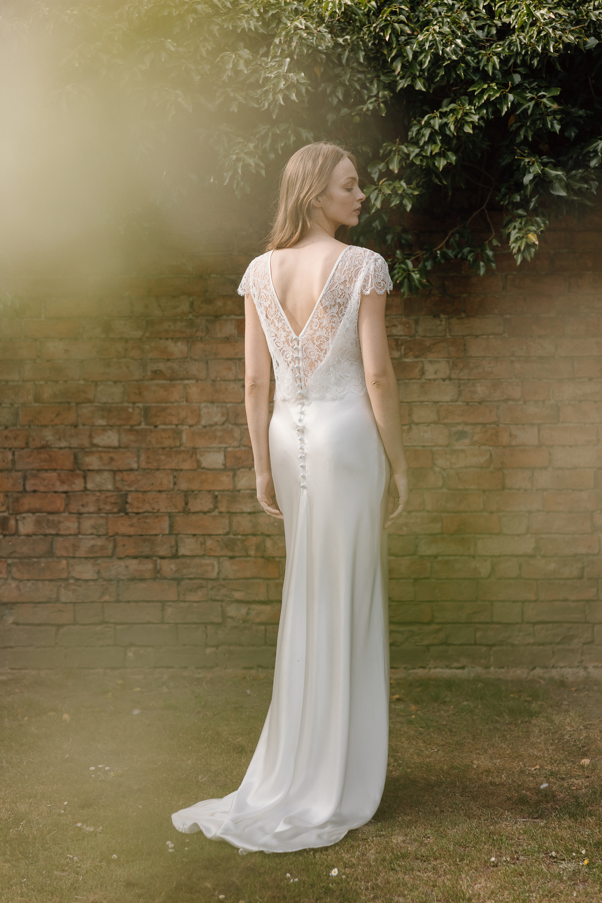 Modern silk and lace wedding dress with V back and lace capped sleeves by Kate Beaumont.