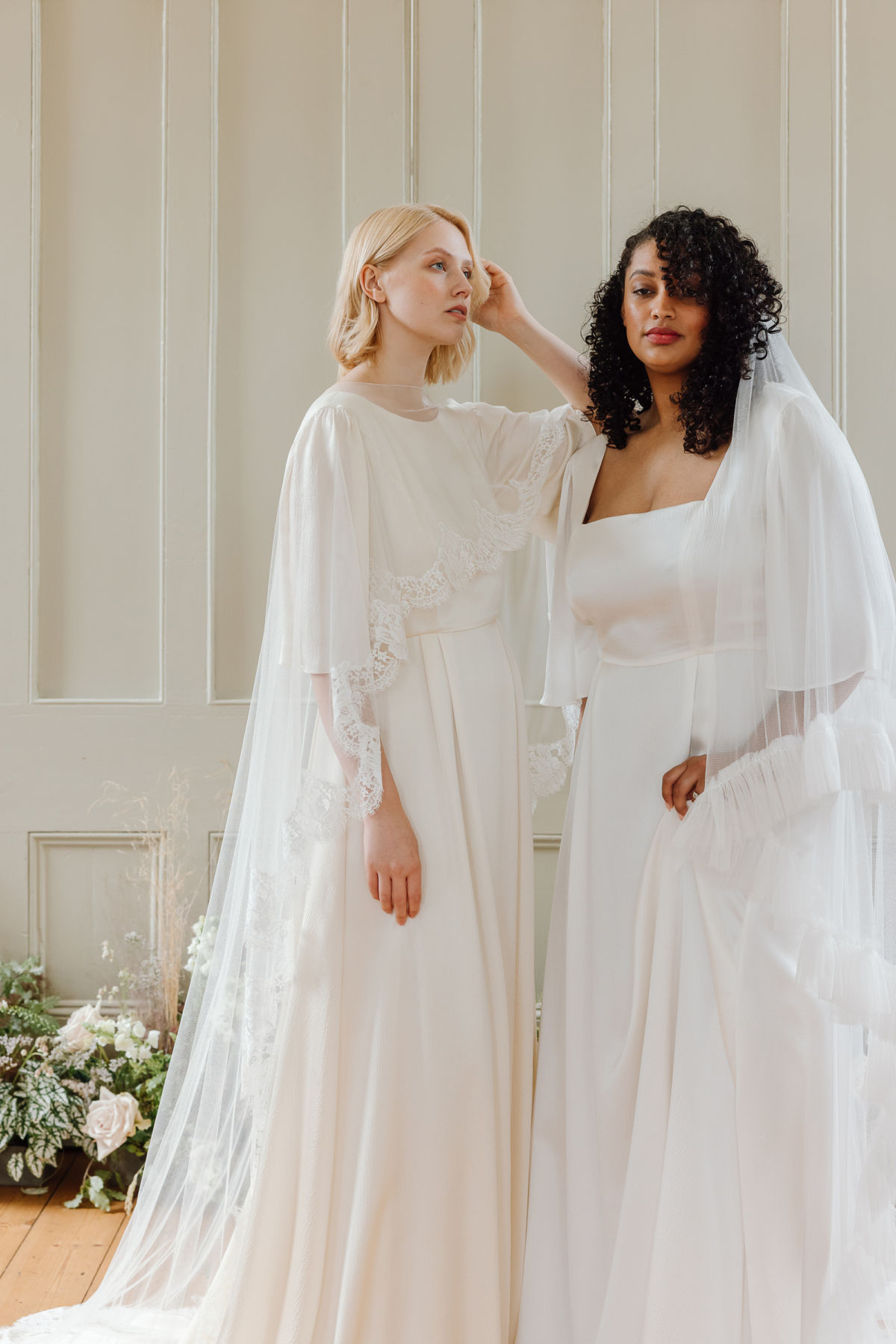 Black curvy model bride and White model bride both wearing modern wedding dress designs by Kate Beaumont.