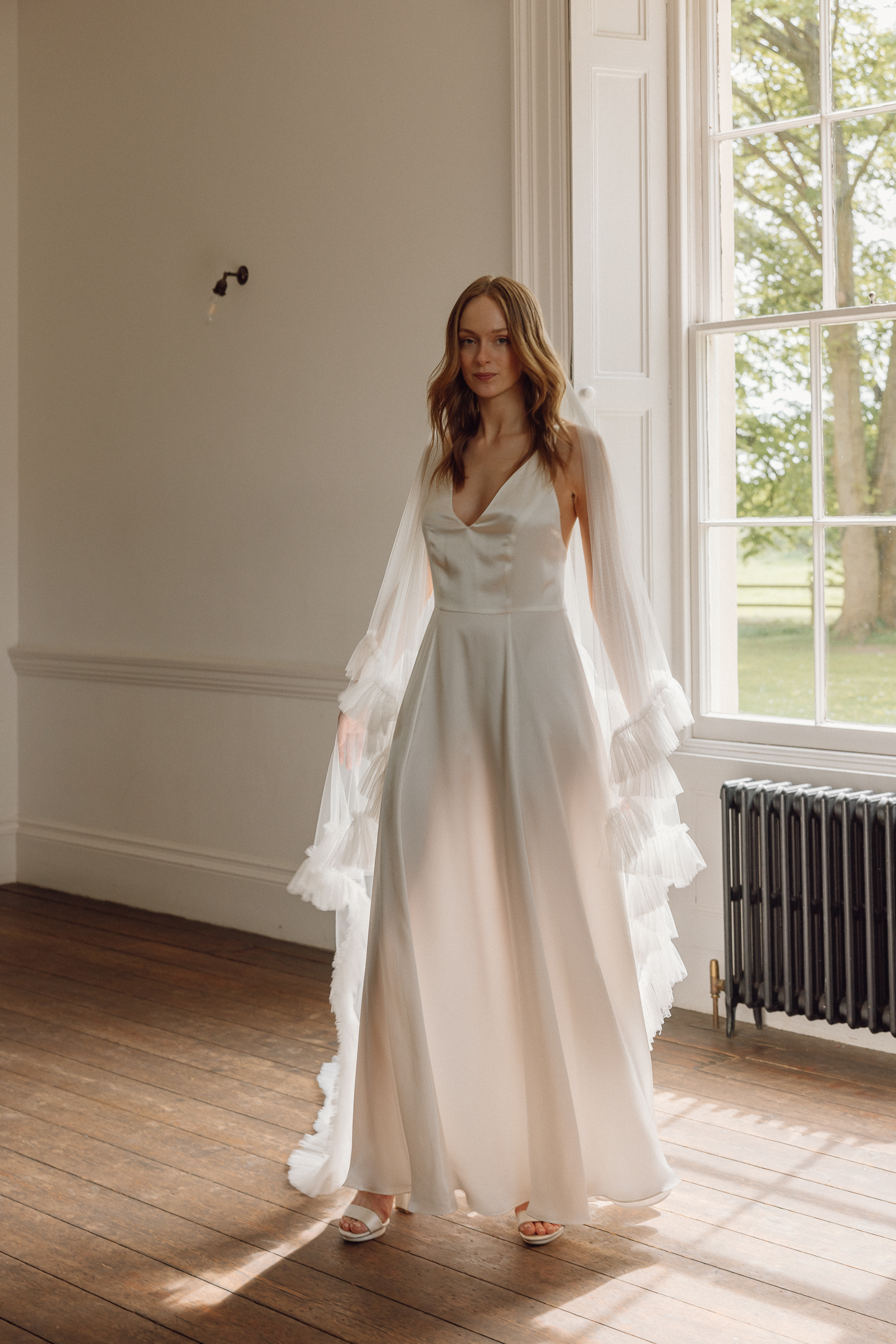 Elegant silk wedding dress by Kate Beaumont  worn with a long tasseled fringed veil.