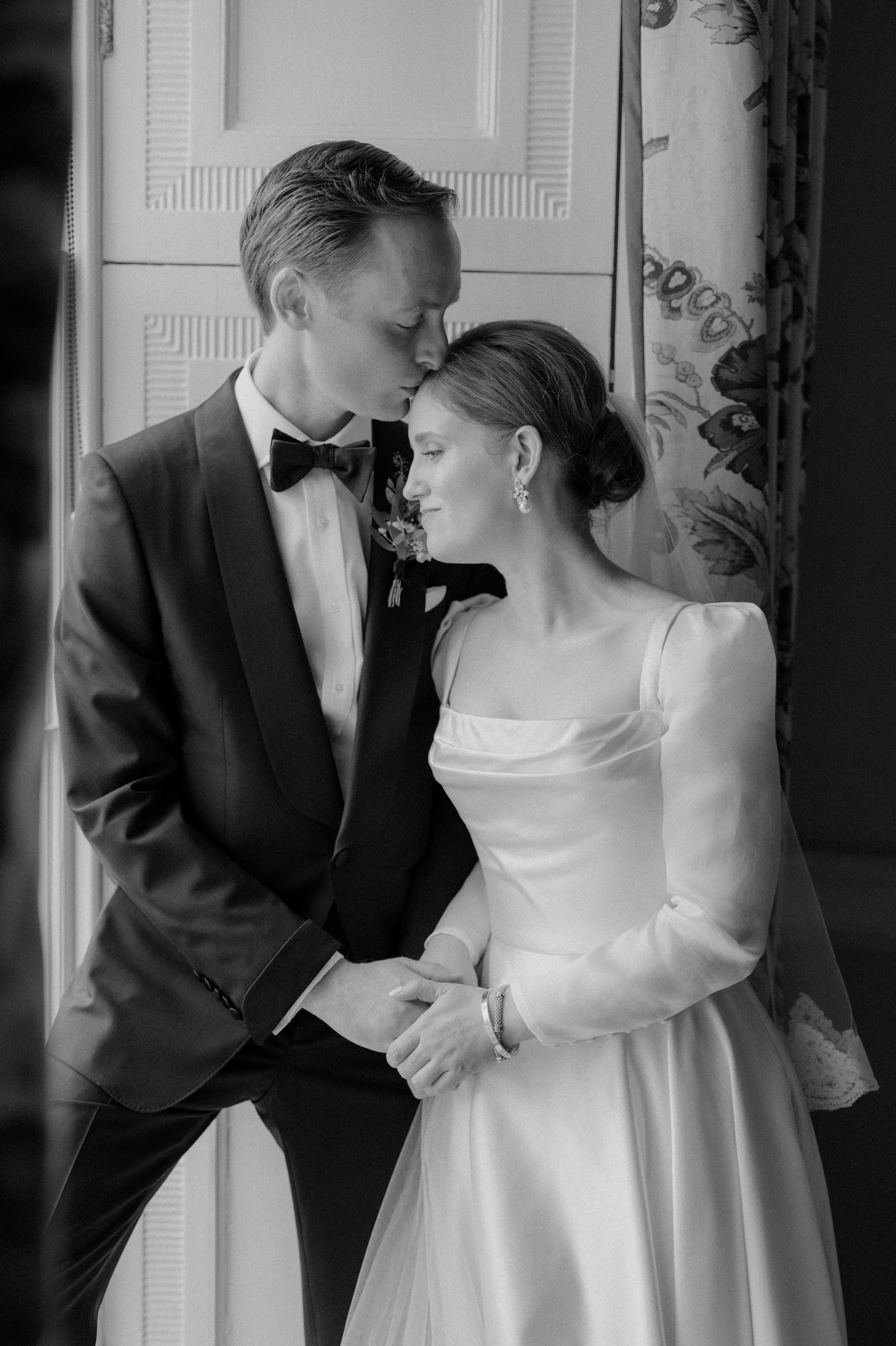 Groom kissing the head of his bride who wears a Phillipa Lepley wedding dress.