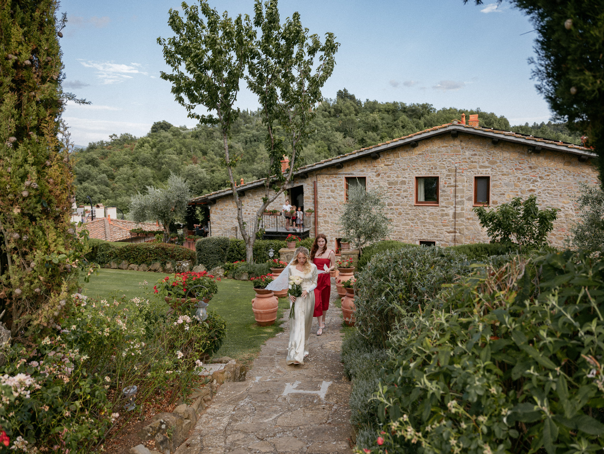 Romantic Tuscan Elopement on Film 105 - An Original 1940s Vintage Dress for Emily & Ned's Intimate Elopement in Tuscany Bride in a 1940s vintage wedding dress wit her single bridesmaid in red on their way to the ceremony for their Italian elopement in Tuscany.