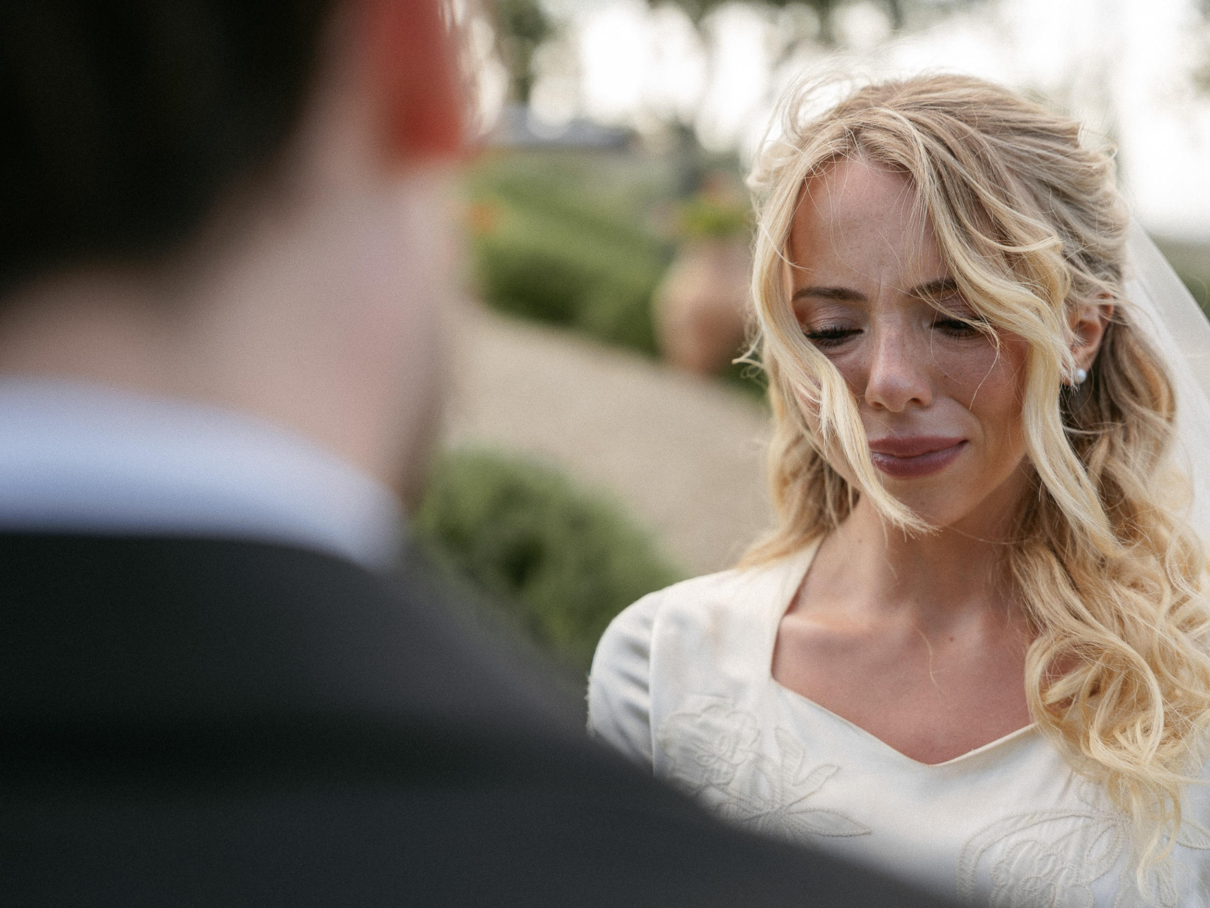 Romantic Tuscan Elopement on Film 142 - An Original 1940s Vintage Dress for Emily & Ned's Intimate Elopement in Tuscany Closeup face shot of emotional bride during her outdoor wedding ceremony. Her hair is caught in a gentle breeze.