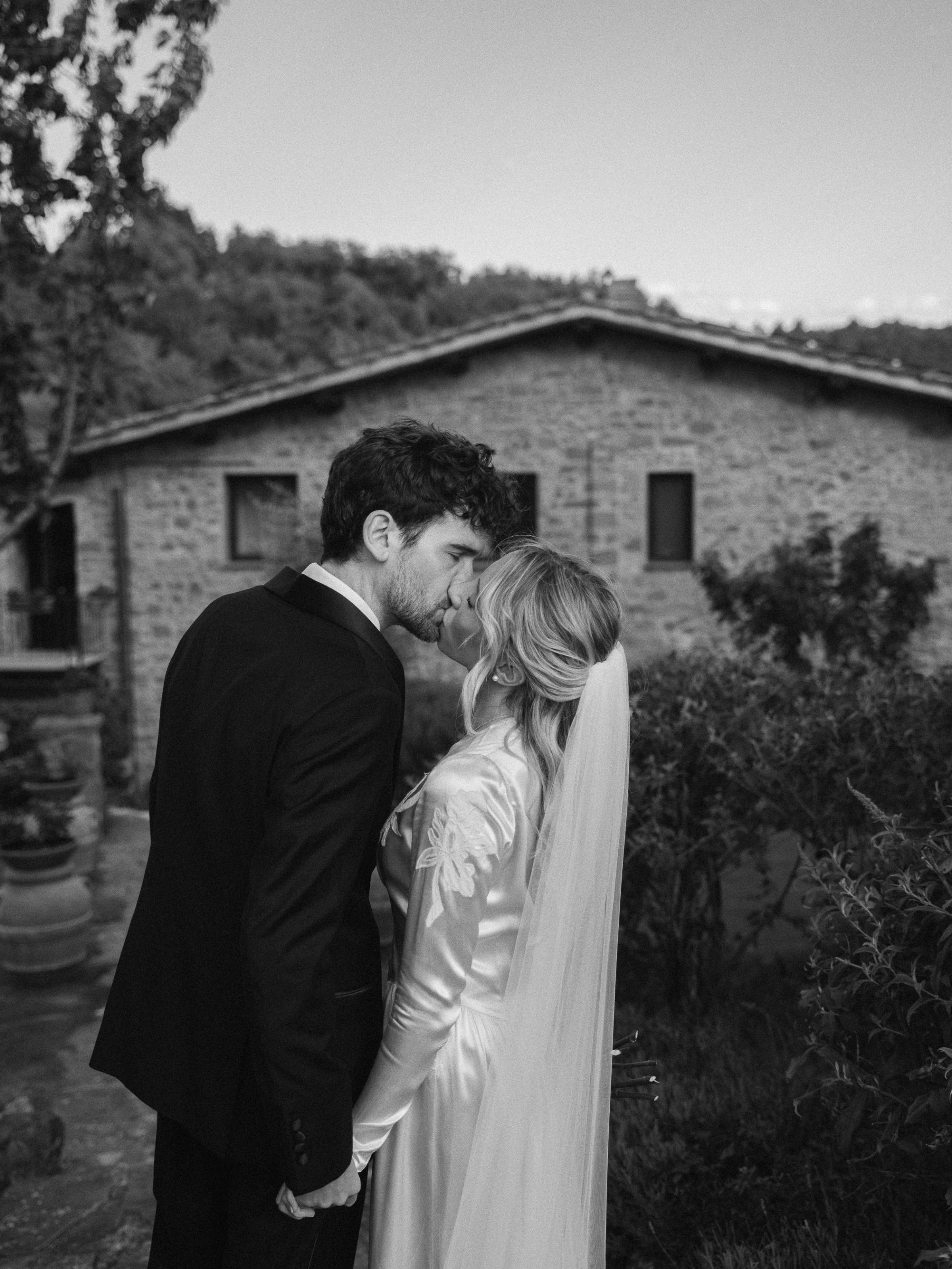 Romantic Tuscan Elopement on Film 175 - An Original 1940s Vintage Dress for Emily & Ned's Intimate Elopement in Tuscany Black and white photograph of the bride and groom kissing in the gardens of their Italian villa. She wears an original 1940's vintage silk wedding dress.