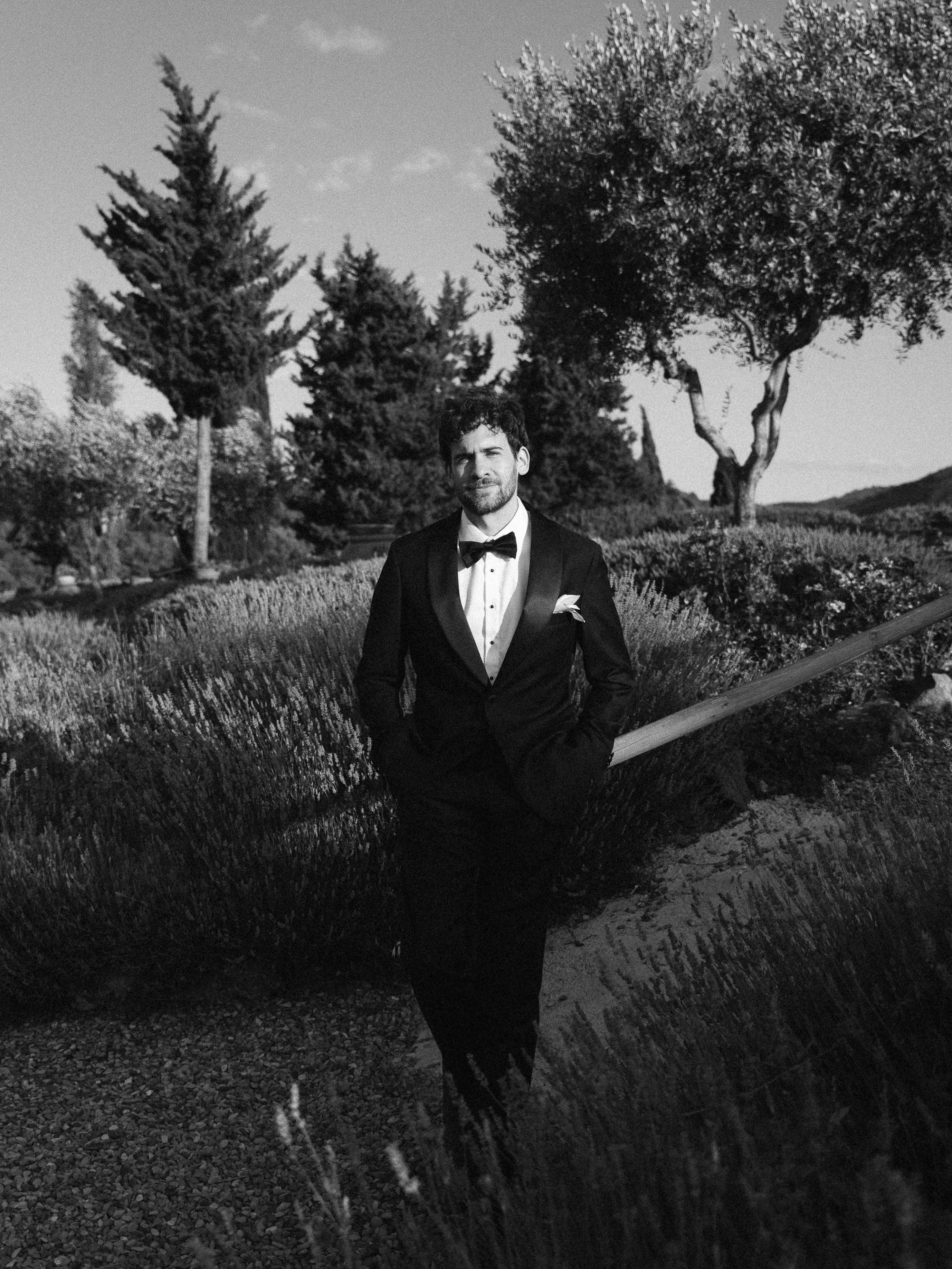 Romantic Tuscan Elopement on Film 234 - An Original 1940s Vintage Dress for Emily & Ned's Intimate Elopement in Tuscany Groom looking cool and confident in black tie standing in the gardens of an Italian villa.