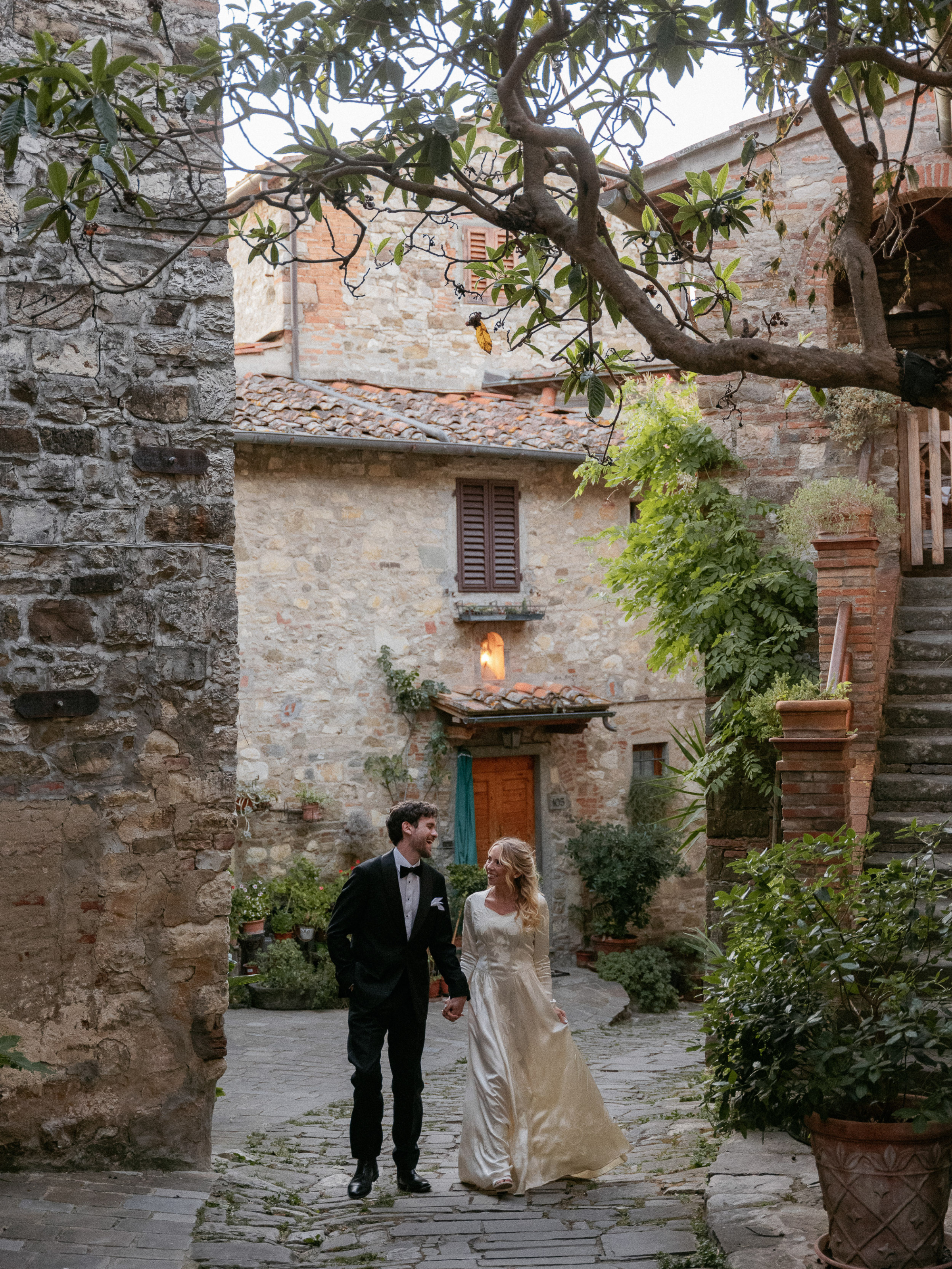 Romantic Tuscan Elopement on Film 325 - An Original 1940s Vintage Dress for Emily & Ned's Intimate Elopement in Tuscany Bride and groom wandering the streets of a traditional town in Tuscany on their elopement day. She wears an original 1940s vintage silk wedding dress. He wears black tie.