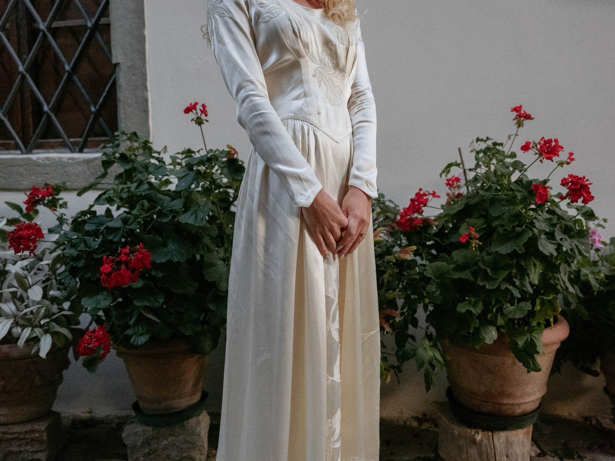 Romantic Tuscan Elopement on Film 336 2 - An Original 1940s Vintage Dress for Emily & Ned's Intimate Elopement in Tuscany Cllose up torso shot of a bride wearing an original 1940's silk wedding dress with long pointed sleeves.