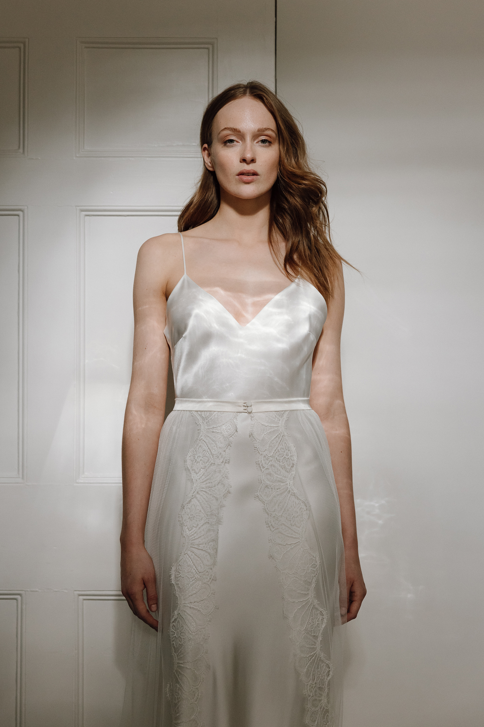 Modern elegant bride wearing silk and elegant barely there lace wedding dress by Kate Beaumont.