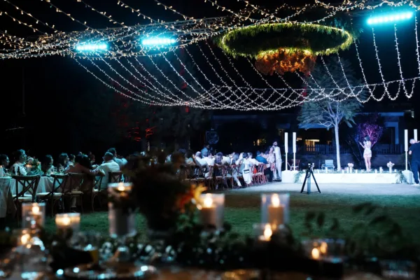 Destination wedding dinner at night with fairy light canopy red uplighting and palm trees in Antalya Turkey by Ramarossi