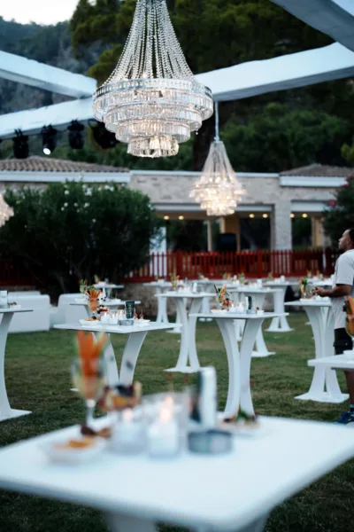 Wedding cocktail hour with crystal chandeliers white high tables and canapes at outdoor venue in Antalya Turkey by Ramarossi