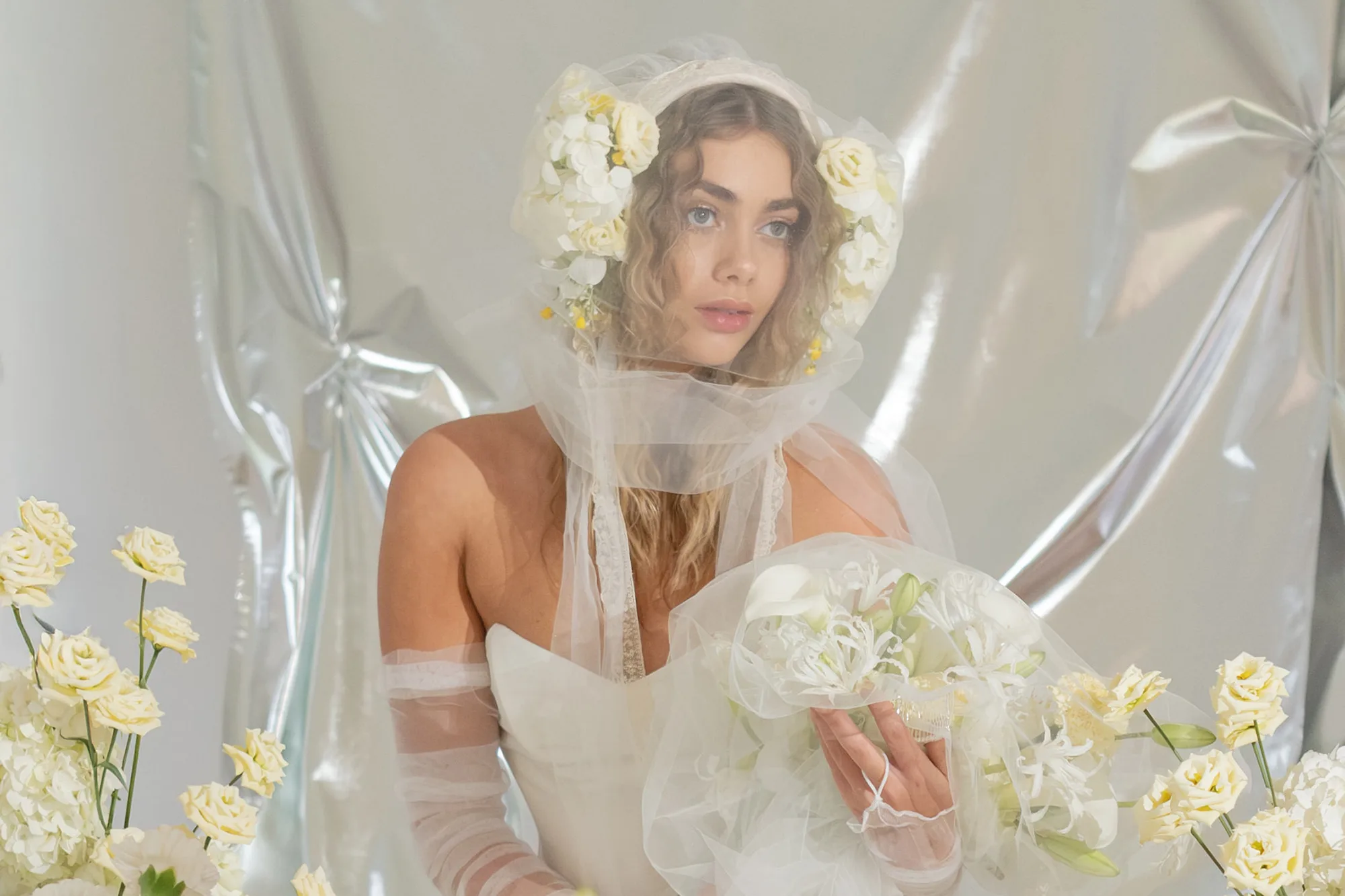 Modern bride with yellow flowers in her hair Princes Leia style and tulle veil covering her face.