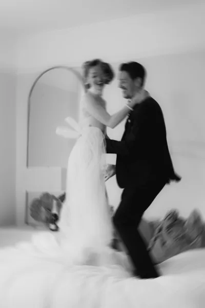 Black and white editorial wedding portrait of bride and groom playfully embracing at Forcett Hall in North Yorkshire, captured by Cleo Stella Photography.