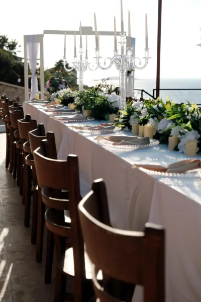 Intimate wedding table with crystal candelabra white florals and sea view on coastal terrace in Kas Turkey by Ramarossi