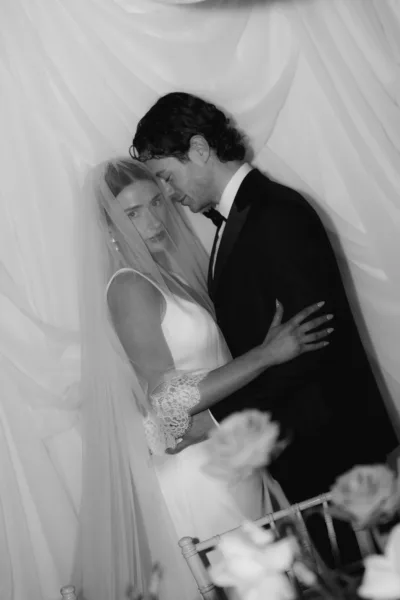 Editorial black and white wedding portrait of bride and groom beneath a veil at Soughton Hall in Cheshire by Cleo Stella Photography.