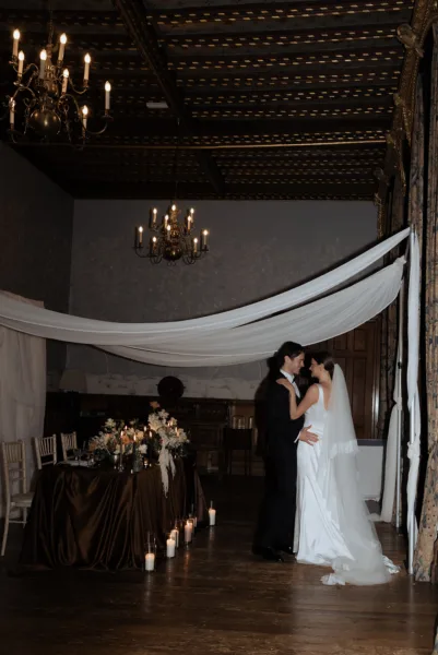 Bride and groom dancing beneath draped ceiling décor and chandeliers at Soughton Hall in Cheshire, captured in an editorial wedding photography style by Cleo Stella Photography.