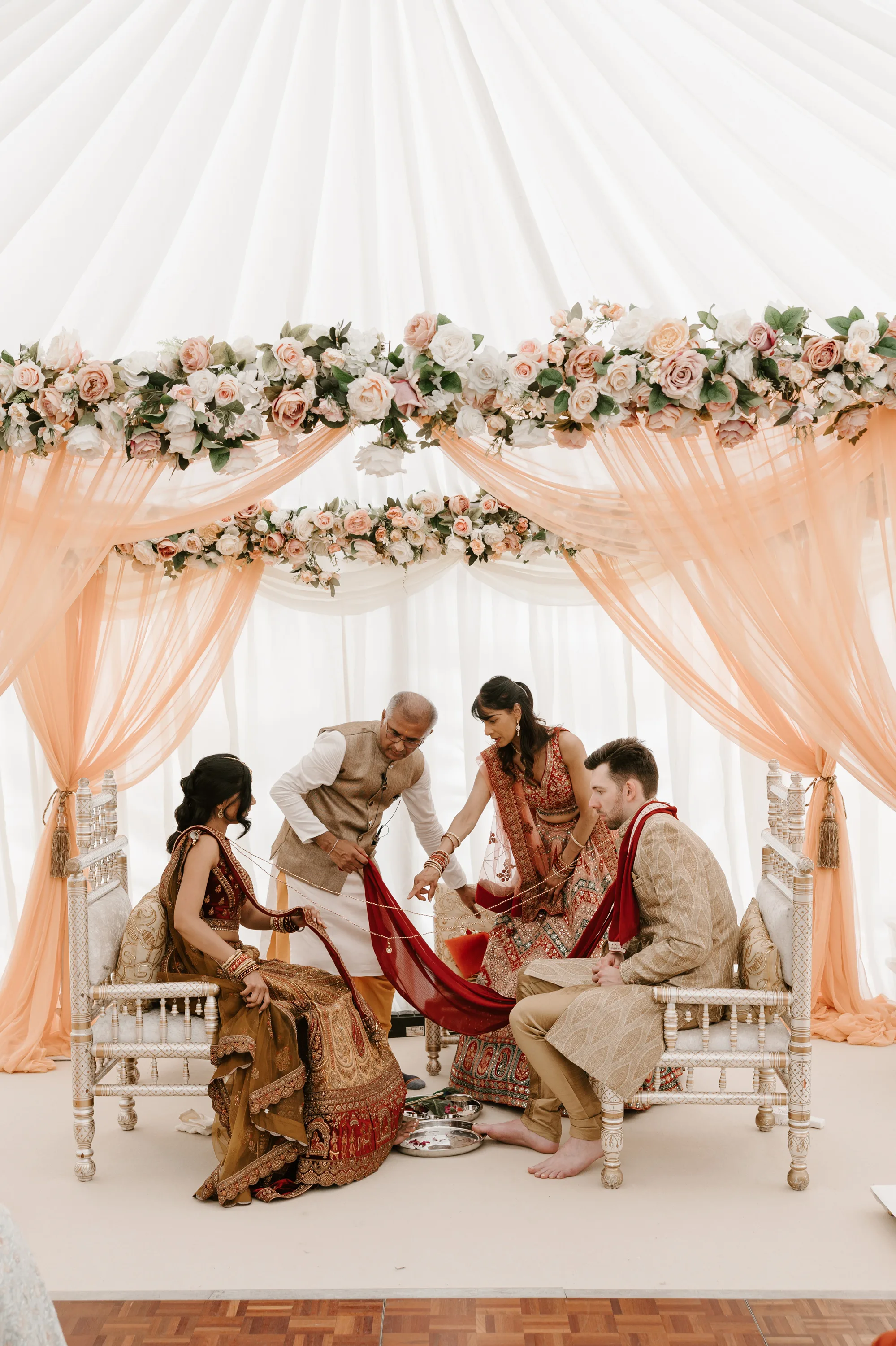 Fusion HIndu Wedding Newburgh Priory 20 - Hema & Will's Fusion Wedding & Hindu Ceremony at Newburgh Priory Hindu wedding ceremony at Newburgh Priory. The ceremony is taking place beneath a mandap draped with peach tulle and decorated with peach flowers.