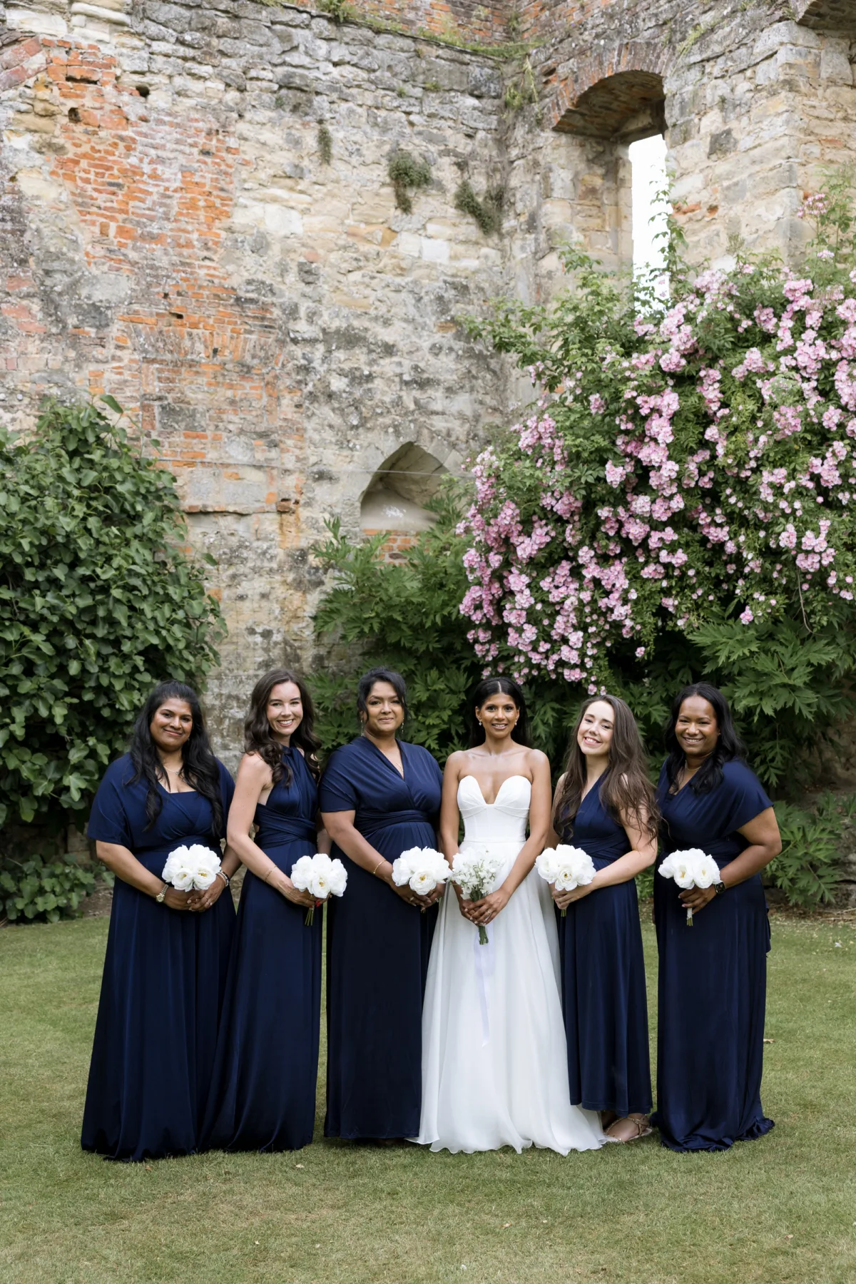 Fusion HIndu Wedding Newburgh Priory 67 - Hema & Will's Fusion Wedding & Hindu Ceremony at Newburgh Priory Bride wearing Suzanne Neville stands with her bridesmaids wearing navy blue for our outdoor wedding ceremony at Newburgh Priory.