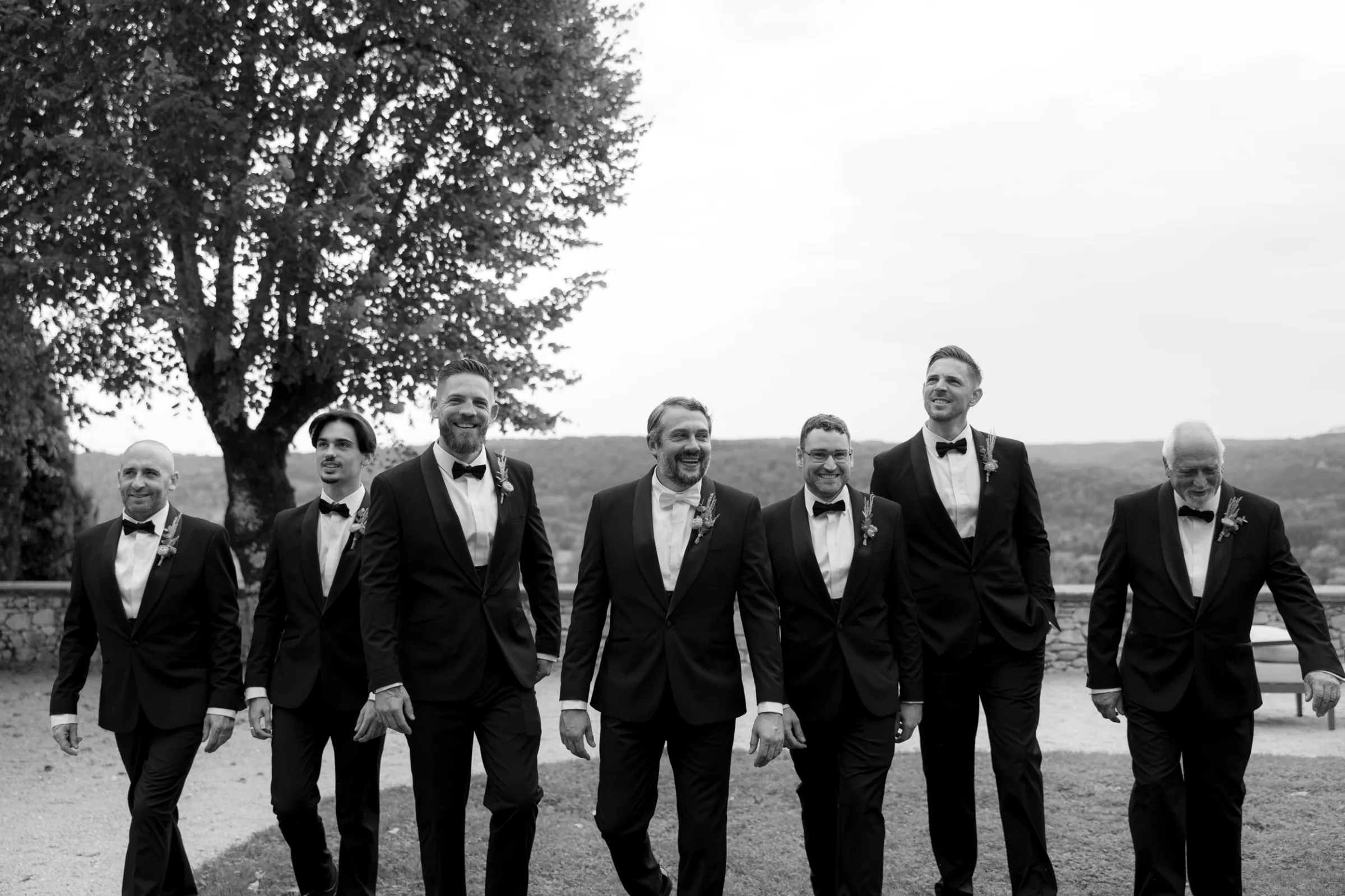 Indie Bride London Chateau Cazenac wedding France 12 - Laura & Ben's Romantic & Intimate Wedding Day Gathering at Chateau Cazenac in The Dordogne Groom and his groomsmen in black tie photographed walking in a row.