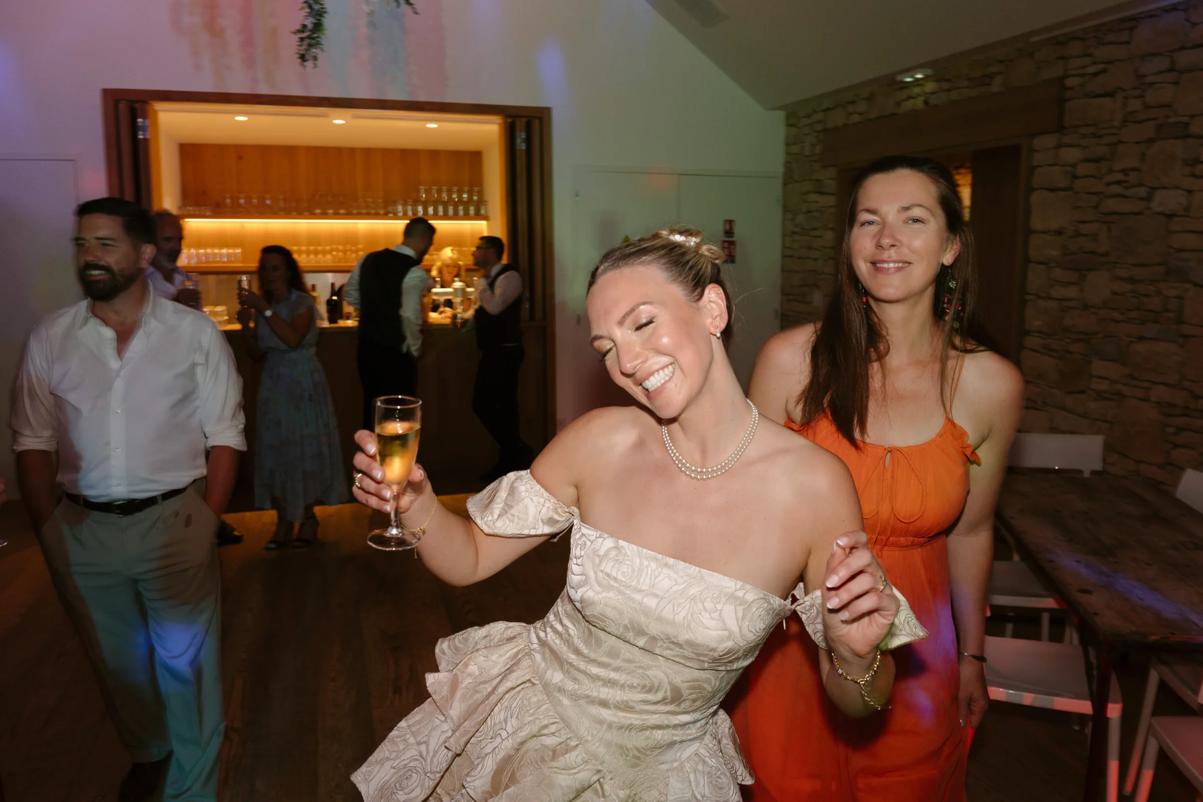 Indie Bride London Chateau Cazenac wedding France 194 - Laura & Ben's Romantic & Intimate Wedding Day Gathering at Chateau Cazenac in The Dordogne Check image of bride in a cute, short tiered mini dress dancing and enjoying a glass oof champagne.