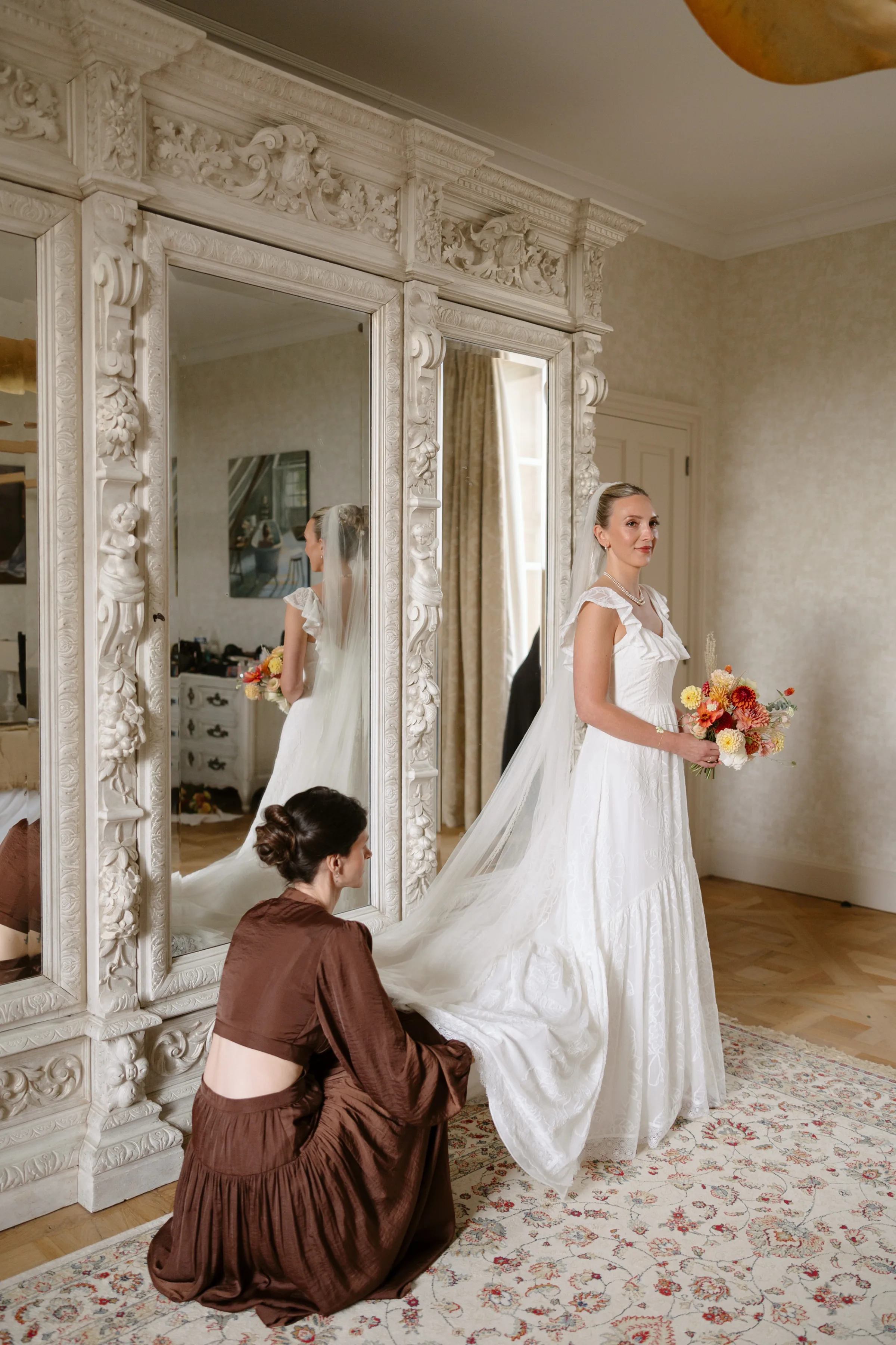 Indie Bride London Chateau Cazenac wedding France 35 - Laura & Ben's Romantic & Intimate Wedding Day Gathering at Chateau Cazenac in The Dordogne Bride getting ready in an Indie Bride London wedding dress. Her blonde hair is red back into a high messy bun. Here bridesmaid wearing brown silk is assisting her into her dress.