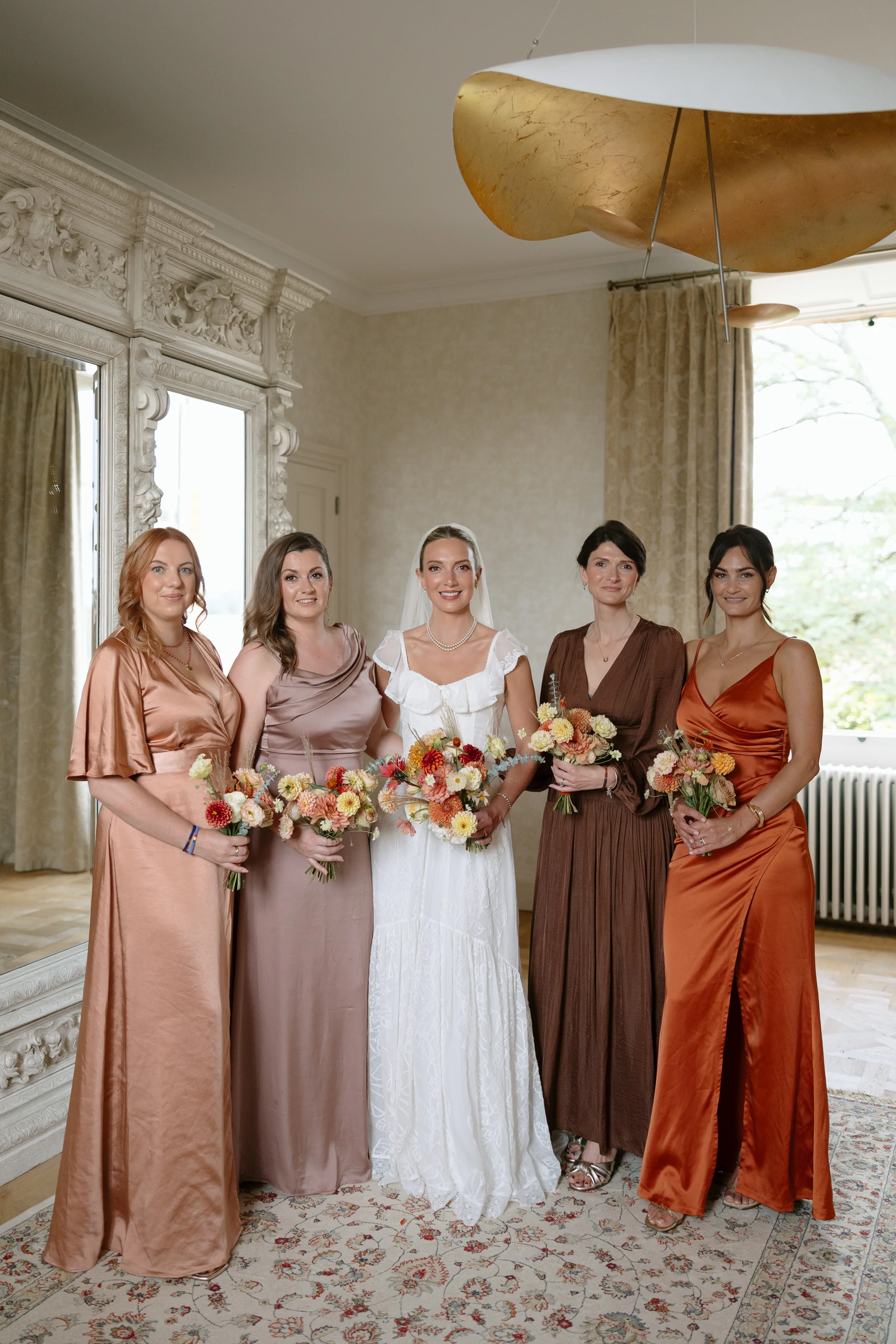 Indie Bride London Chateau Cazenac wedding France 41 - Laura & Ben's Romantic & Intimate Wedding Day Gathering at Chateau Cazenac in The Dordogne Bride standing with her bridesmaids in the getting ready suit. She wears a ruffle sleeved wedding dress and her bridesmaids wear a mix of Autumnal colour dresses from ASOS and Six Stories.