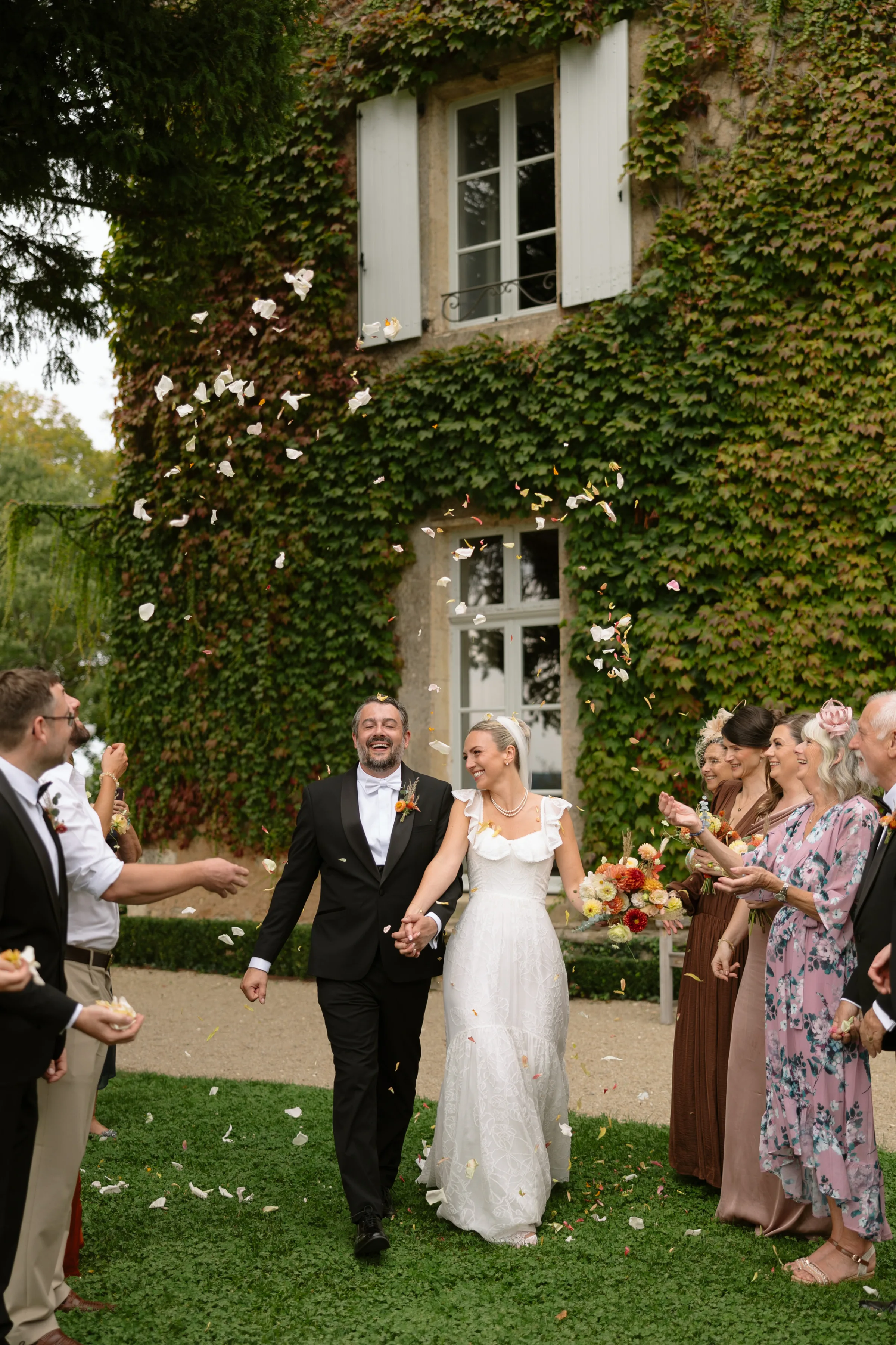 Indie Bride London Chateau Cazenac wedding France 69 - Laura & Ben's Romantic & Intimate Wedding Day Gathering at Chateau Cazenac in The Dordogne Bride and groom being showered in confetti in the grounds of Chateau Cazenac in France.