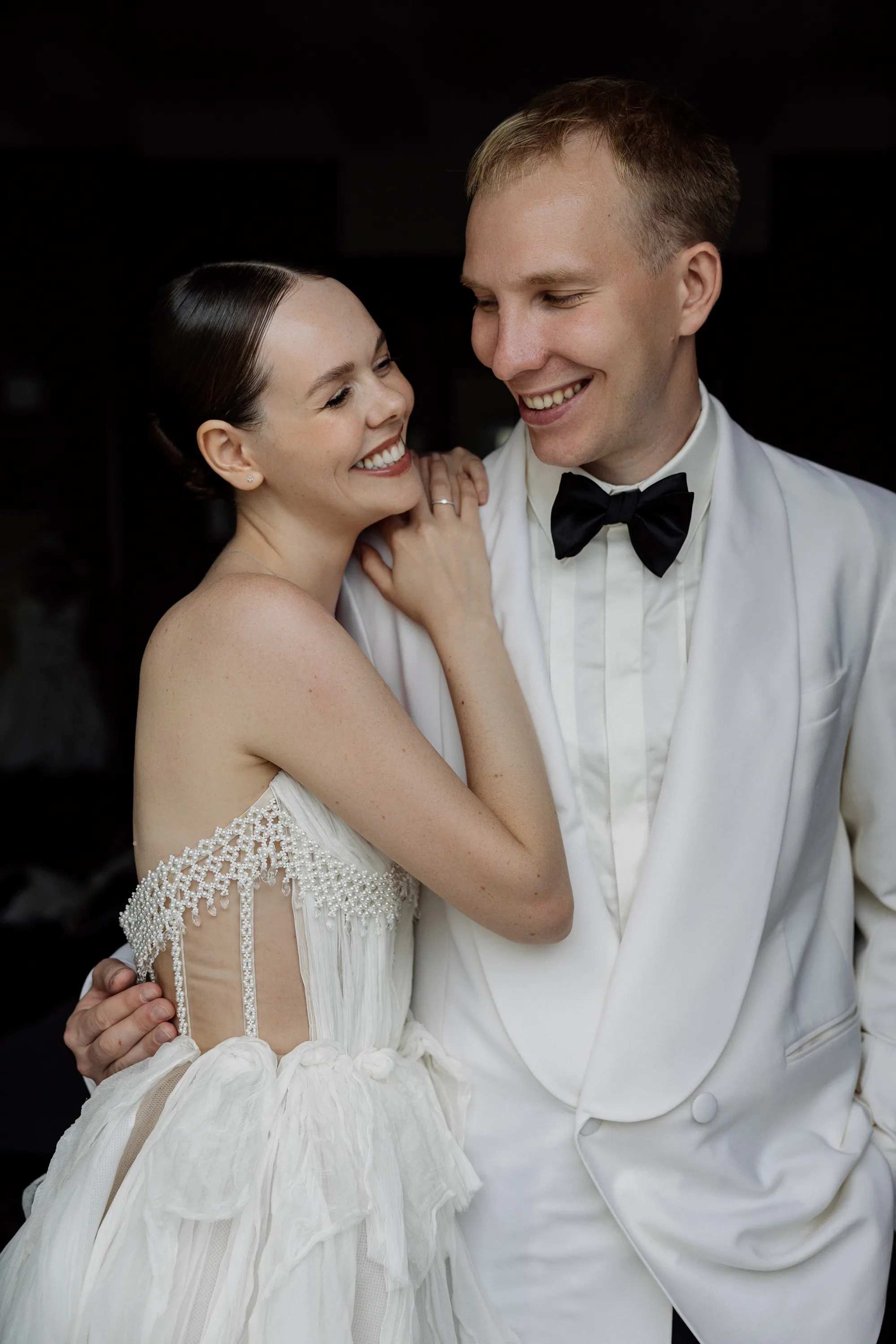 Montenegro Wedding 28 - A Romantic & Intimate Montenegro Wedding at Villa Shah, Inspired by 'La Vita Nobile' Happy smiling bride and groom. The groom in a white tuxedo and black bow tie has his arm around the waist of the bride who wears a Rara Couture wedding dress.