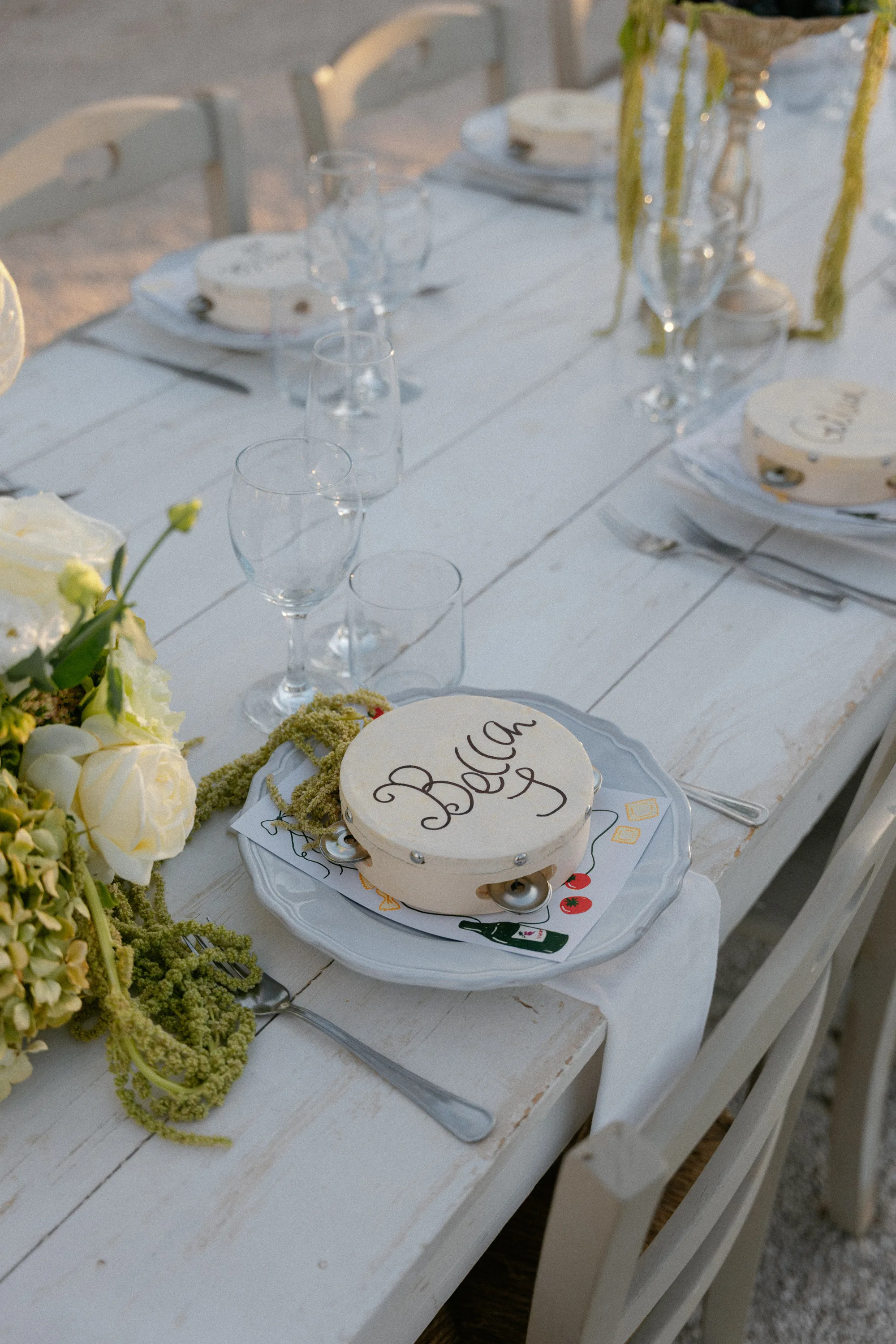 Multiple Day Destination Wedding in Masseria Potenti Puglia Italy 104 - Yael Wore Chana Marelus & A Handmade Beaded Veil for her Relaxed Italian Masseria Wedding Tambourine wedding favours placed on a plate for a wedding iatMasseria Potenti wedding venue in Puglia Italy. White roses and greenery trailing nearby.