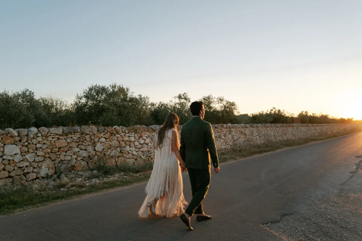 Multiple Day Destination Wedding in Masseria Potenti Puglia Italy 122 - Yael Wore Chana Marelus & A Handmade Beaded Veil for her Relaxed Italian Masseria Wedding Masseria Potenti wedding venue in Puglia Italy. Bride wearing a Chana Marelus tassel dress and beaded veil walking with her groom during golden hour.