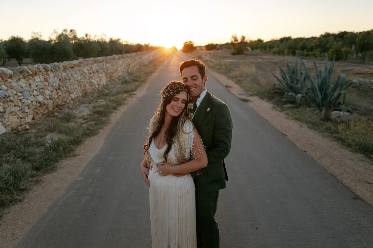 Multiple Day Destination Wedding in Masseria Potenti Puglia Italy 128 - Yael Wore Chana Marelus & A Handmade Beaded Veil for her Relaxed Italian Masseria Wedding Masseria Potenti wedding venue in Puglia Italy. Bride wearing a Chana Marelus tassel dress and beaded veil standing by her groom during golden hour.