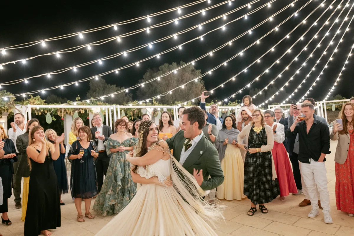 Multiple Day Destination Wedding in Masseria Potenti Puglia Italy 137 - Yael Wore Chana Marelus & A Handmade Beaded Veil for her Relaxed Italian Masseria Wedding Bride in a Bride Chana Marelus tassel dress and beaded veil dancing under a canopy of twinkly lights. Puglia Italy wedding.