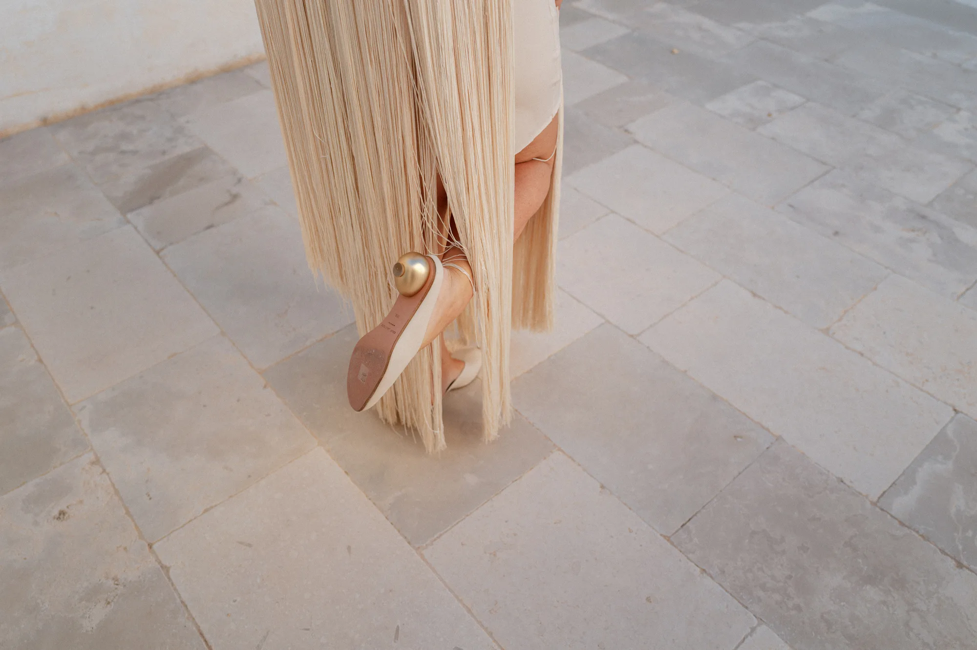 Multiple Day Destination Wedding in Masseria Potenti Puglia Italy 19 - Yael Wore Chana Marelus & A Handmade Beaded Veil for her Relaxed Italian Masseria Wedding Bride wearing a Chana Marelus with tassels and Gray Matters shows with gold heels.