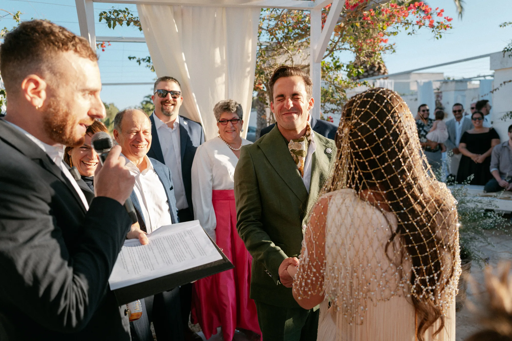 Multiple Day Destination Wedding in Masseria Potenti Puglia Italy 75 - Yael Wore Chana Marelus & A Handmade Beaded Veil for her Relaxed Italian Masseria Wedding Groom closing his eyes and smiling during the wedding ceremony. He wears a green suit and cravat.