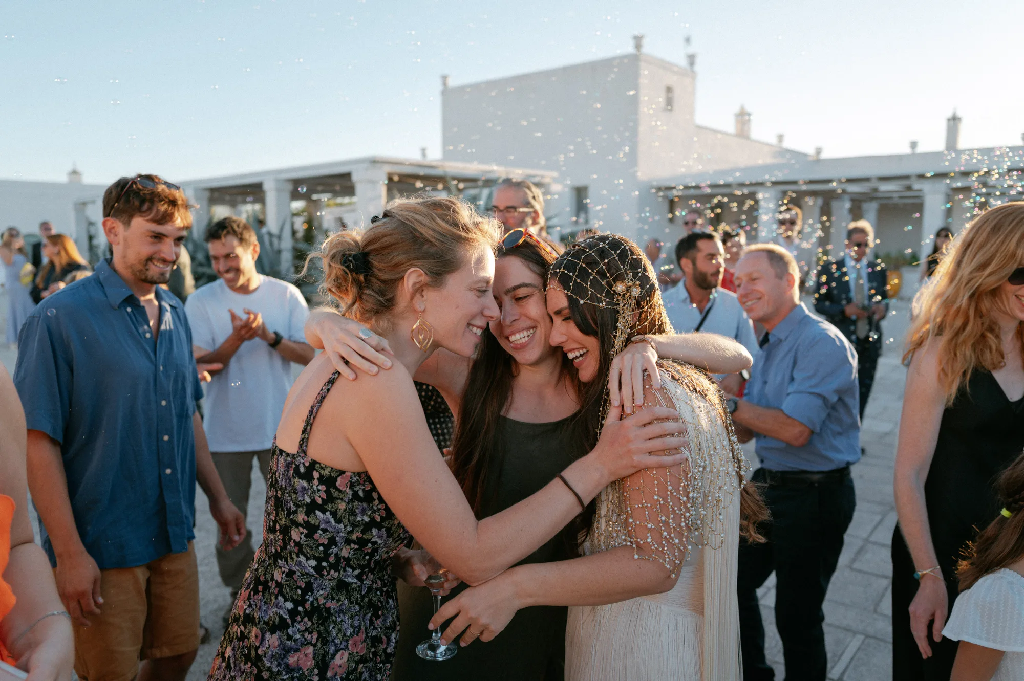 Multiple Day Destination Wedding in Masseria Potenti Puglia Italy 97 2 - Yael Wore Chana Marelus & A Handmade Beaded Veil for her Relaxed Italian Masseria Wedding Bride in a beaded wedding veil being hugged tightly by a happy wedding guest. Puglia Italy wedding.