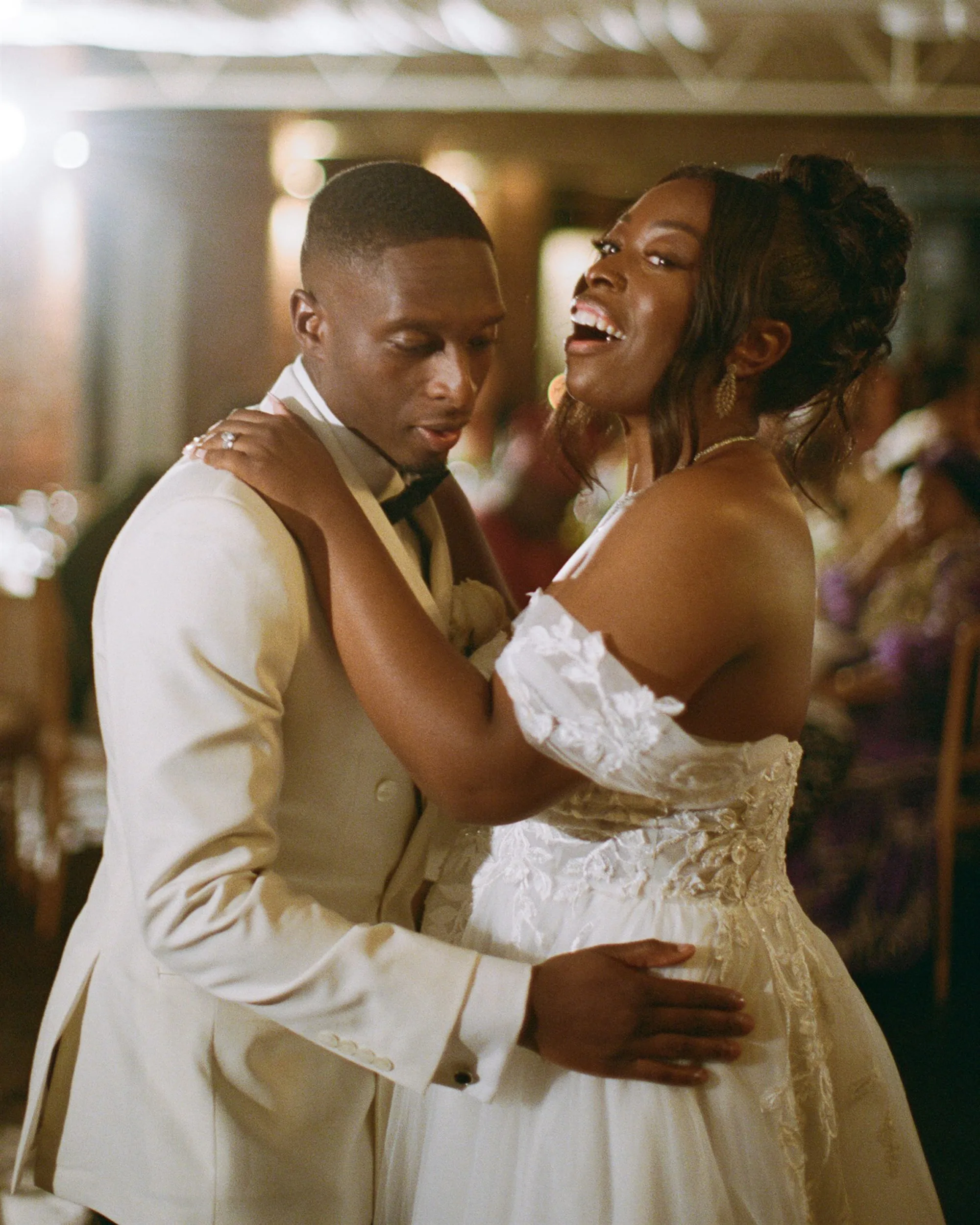 Black bride and groom embracing one another on the dance floor