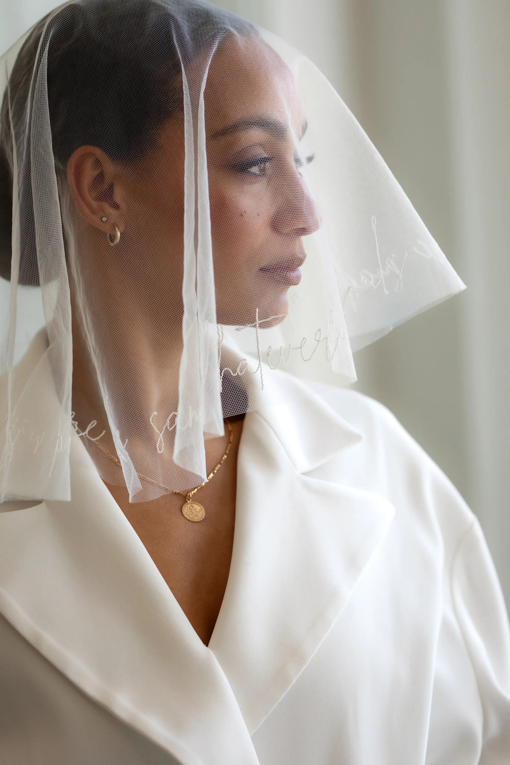 Rebecca Anne Designs embroidered wedding veils 71 - Introducing the New Embroidered Wedding Veil & Bridal Accessories Collection by Rebecca Anne Designs Bride wearing a short neck length veil over here face. The edges are embroidered with words. Embroidery by Rebecca Anne Designs.