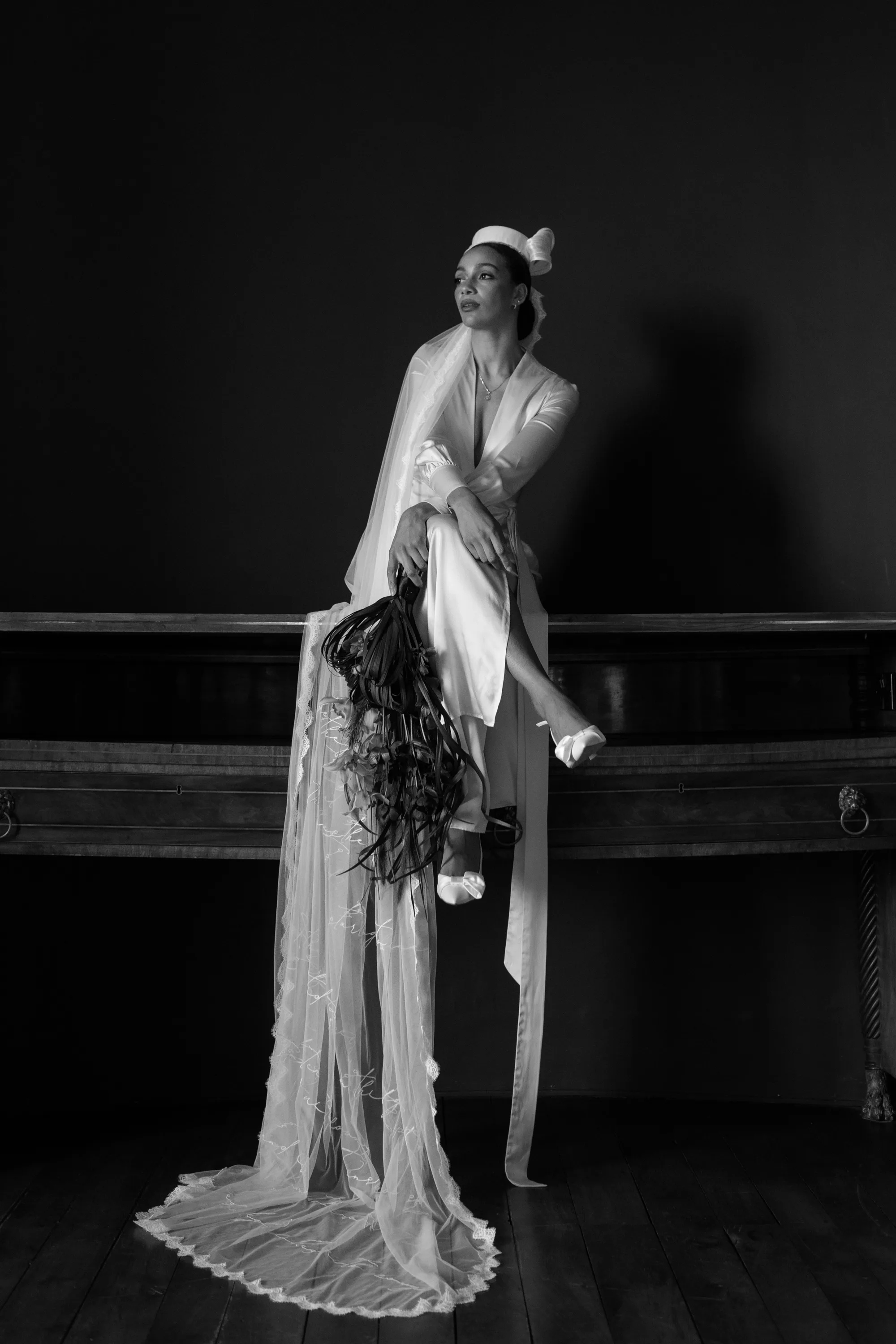 Rebecca Anne Designs embroidered wedding veils 77 - Introducing the New Embroidered Wedding Veil & Bridal Accessories Collection by Rebecca Anne Designs Black model bride seated and wearing a pillbox hat with an embroidered veil by Rebecca Anne Designs. Her dress features a sheer tulle panel also embroidered.