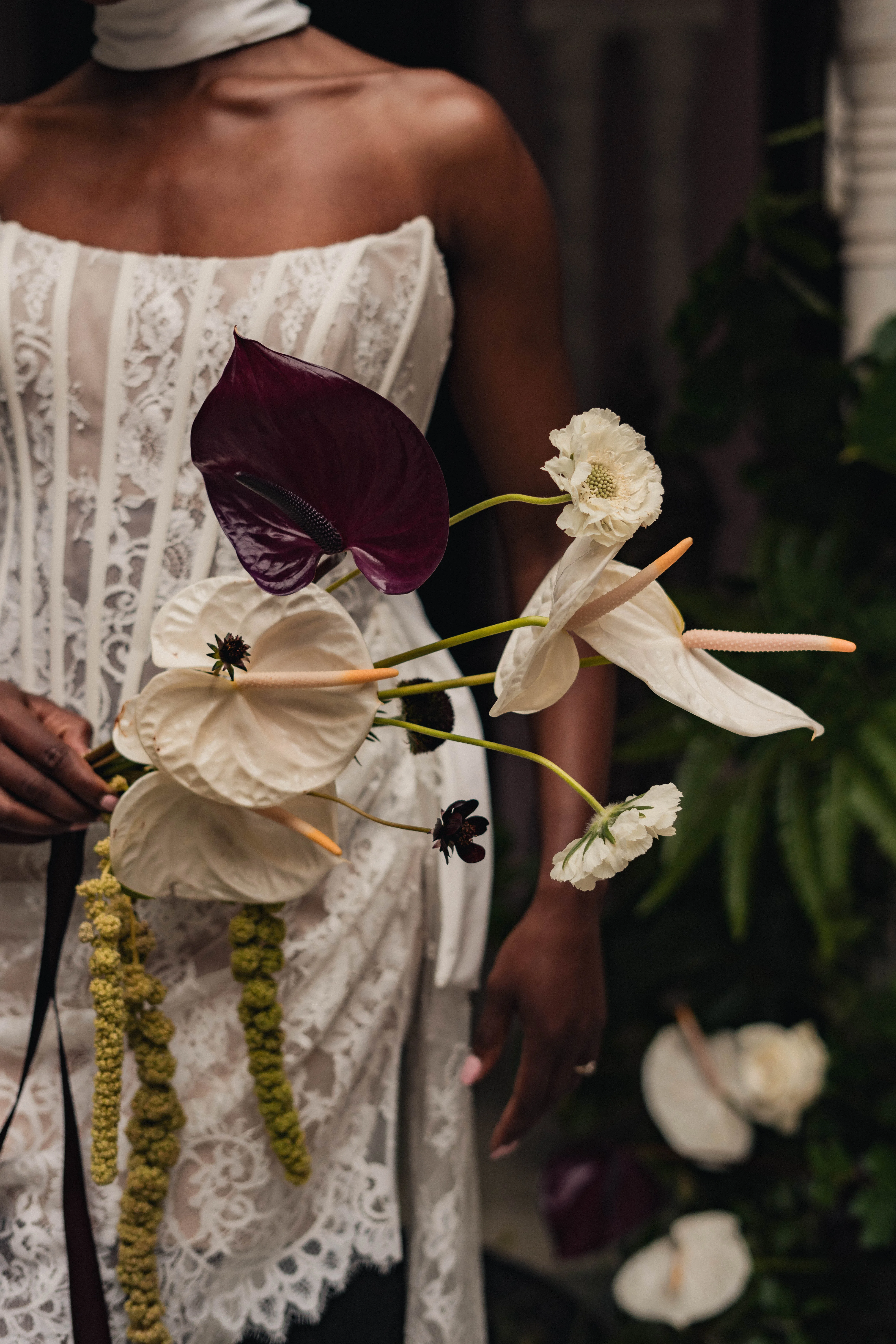 SS Port Lympne Safari Park New Orleans Wedding Editorial The Chamberlins Film Medium Format Photography London Surrey 278 2 - Wedding Inspiration That Celebrates The Joy, Diversity & Vibrancy of New Orleans Close up shot of a Black bride holding a modern wedding bouquet with large white and dark red orchids.