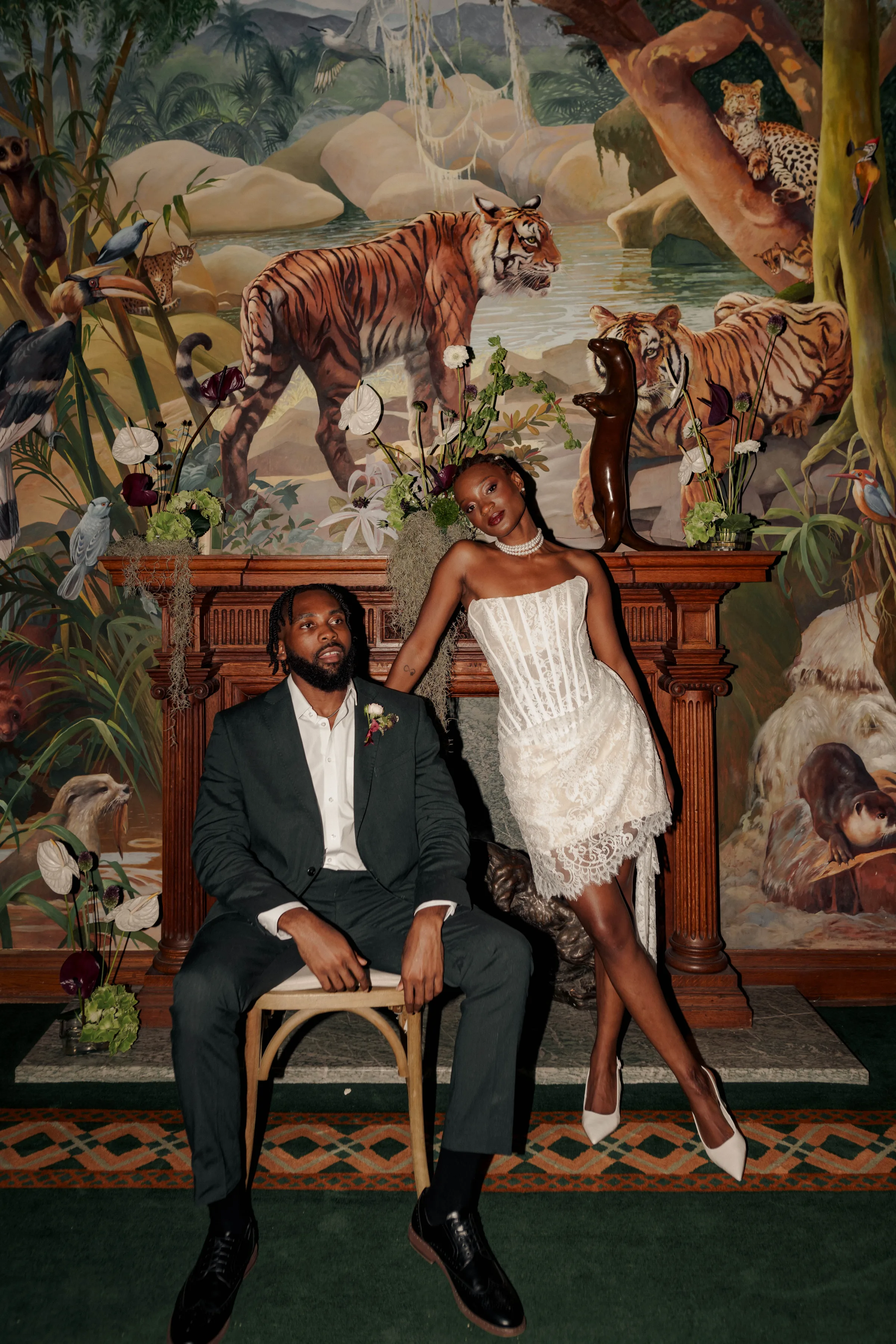 SS Port Lympne Safari Park New Orleans Wedding Editorial The Chamberlins Film Medium Format Photography London Surrey 747 - Wedding Inspiration That Celebrates The Joy, Diversity & Vibrancy of New Orleans Mardi Gras and New Orleans inspired wedding editorial featuring Black bride and groom. Bride wears a corseted mini lace dress and groom wears. Dark green suit with the top buttons of his shirt undone.