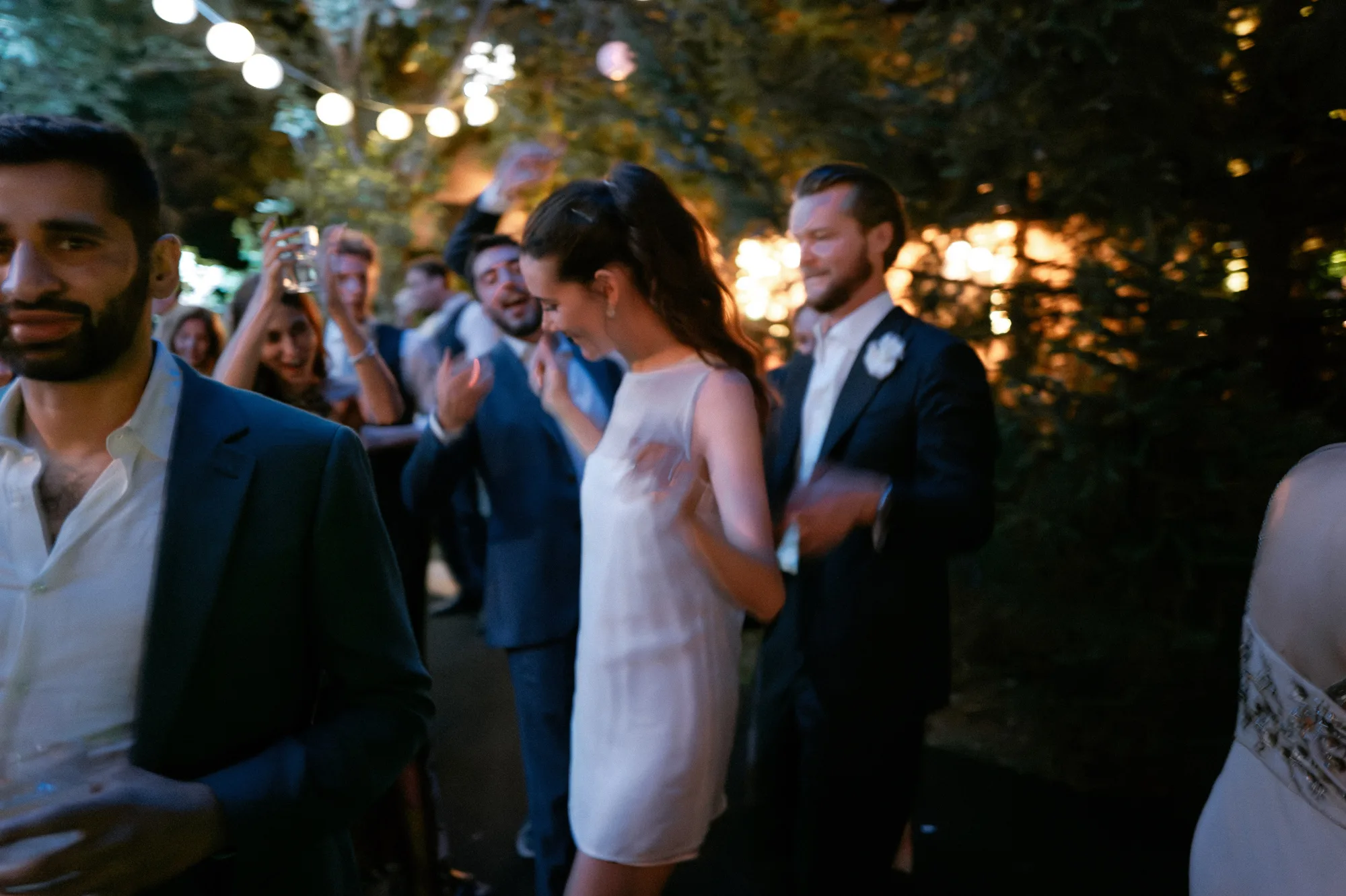 Bride in a mini dress dancing with her groom on the evening of her private Italian villa wedding.