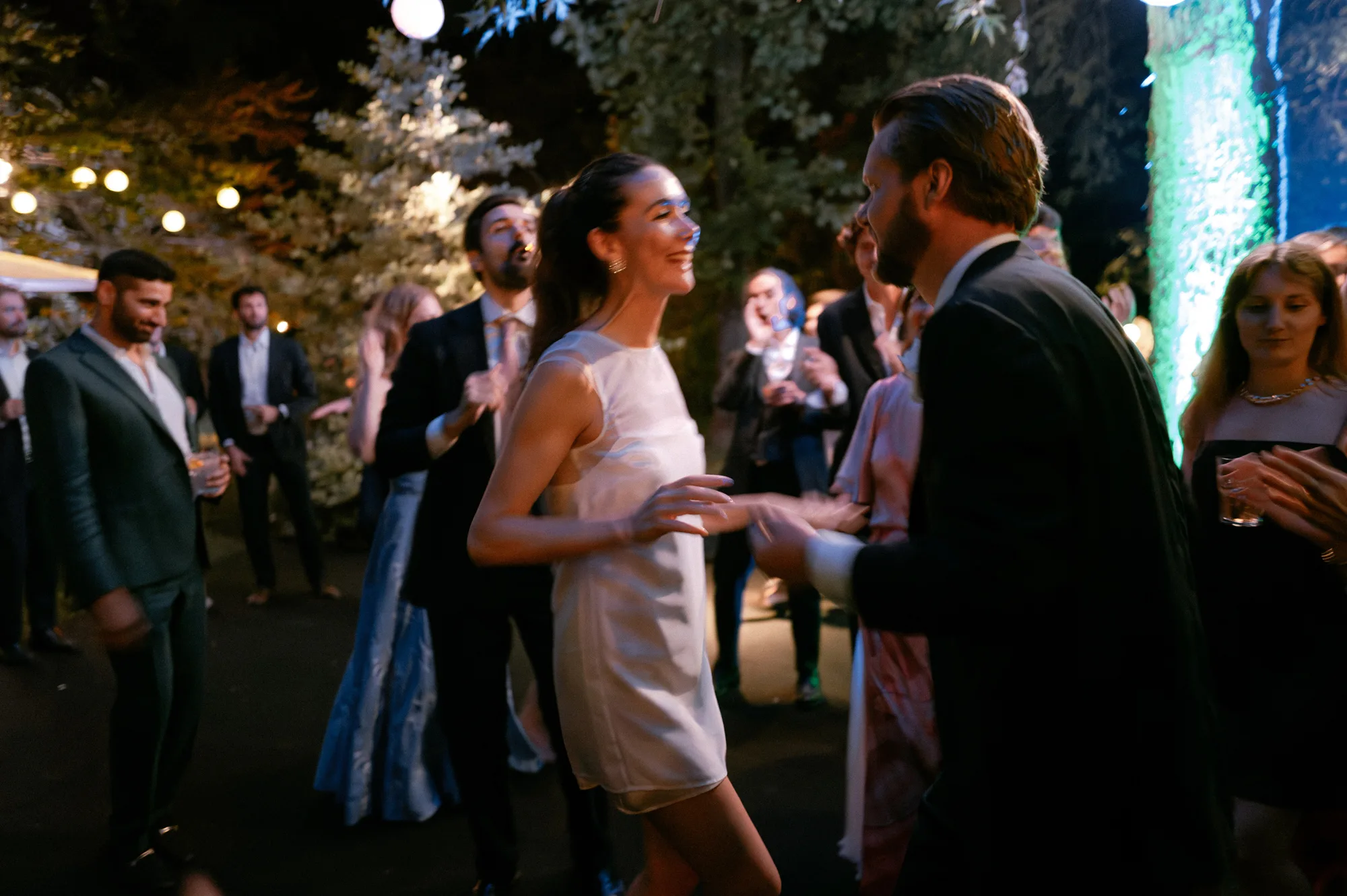 Bride in a mini dress dancing with her groom on the evening of her private Italian villa wedding.